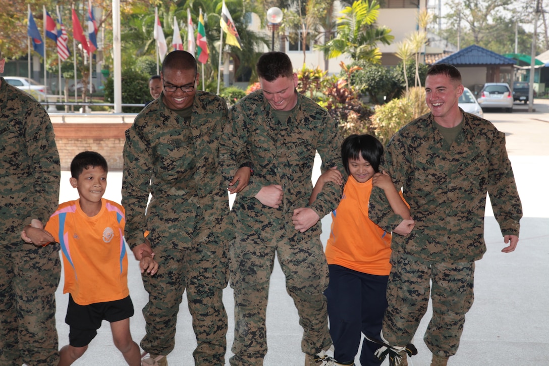 U.S. Marines and sailors team up with students from the Panya Nukhoon School in Nakhon Ratchasima, Kingdom of Thailand, Feb. 12 during a three-legged race at a community relations event during exercise Cobra Gold 2013. The Marines and sailors took time to attend the school and give the children an opportunity to interact with U.S. service members. CG 13, in its 32nd iteration, is a multinational exercise that promotes regional prosperity, security and cooperation among partner militaries. The service members are with 1st Marine Aircraft Wing, III Marine Expeditionary Force.