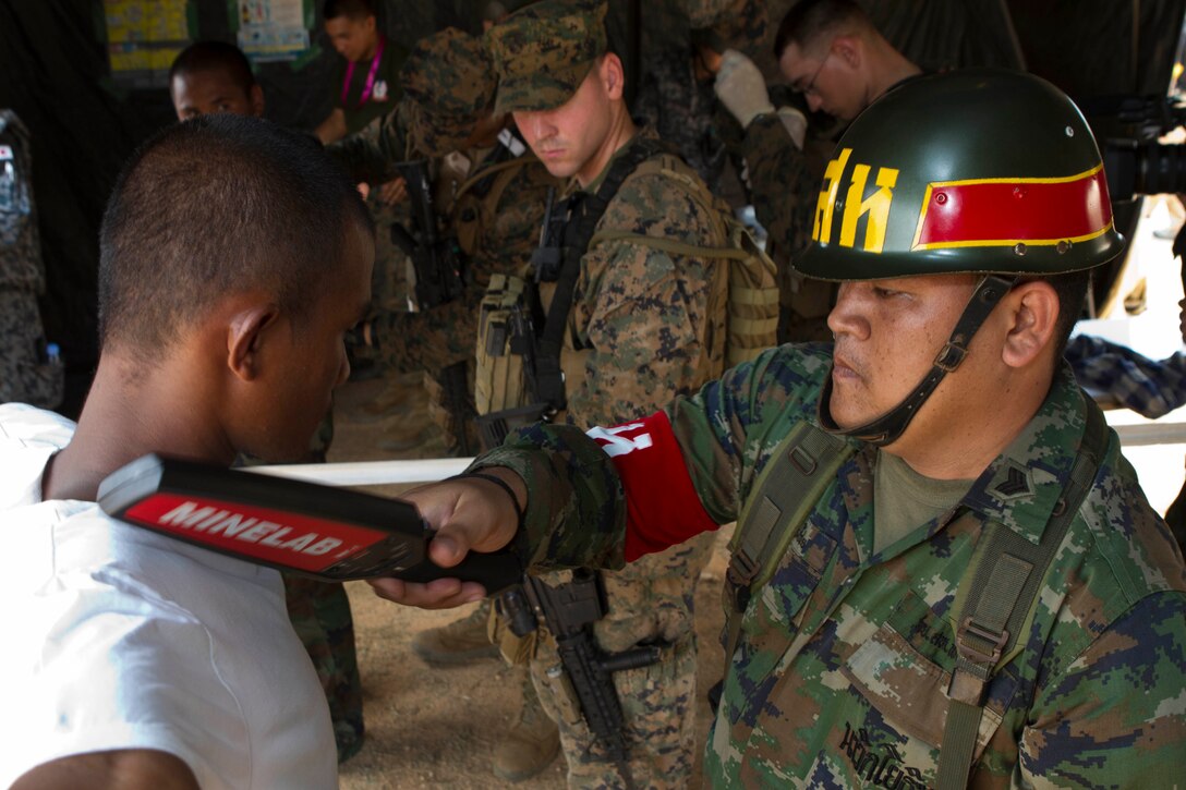 Sergeant Thong Chai, a military policeman with Military Police Division, Royal Thai Marine Corps, uses a metal detector to scan a Thai citizen for weapons during a multilateral non-combatant evacuation operation as a part of Cobra Gold 2013 here, Feb. 17. Cobra Gold is the largest multinational exercise in the Asia-Pacific and helps reinforce the foundation and framework for a multinational force to respond rapidly and effectively to regional crises. The 31st MEU is the only continuously forward-deployed MEU and is the Marine Corps’ force in readiness in the Asia-Pacific region.