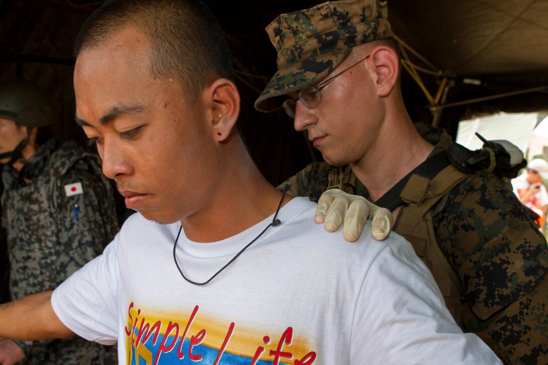 Lance Cpl. Thomas J. Spengler, a military policeman with Combat Logistics Battalion 31, 31st Marine Expeditionary Unit, searches a Thai citizen during a multilateral non-combatant evacuation operation as a part of Cobra Gold 2013 here, Feb. 17. Cobra Gold is the largest multinational exercise in the Asia-Pacific and helps develop the ability of all participants to effectively conduct humanitarian assistance and disaster relief operations. The 31st MEU is the only continuously forward-deployed MEU and is the Marine Corps’ force in readiness in the Asia-Pacific region.