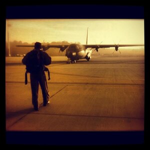 Joshua Williams, 366th Security Forces Squadron investigator, walks toward a C-130 Hercules on an airfield in Germany before deploying to another location. As a former Phoenix Raven, Williams, native of Palatine, Ill., was charged with providing security for aircraft and personnel transiting high terrorist and criminal threat areas. (Courtesy photo)