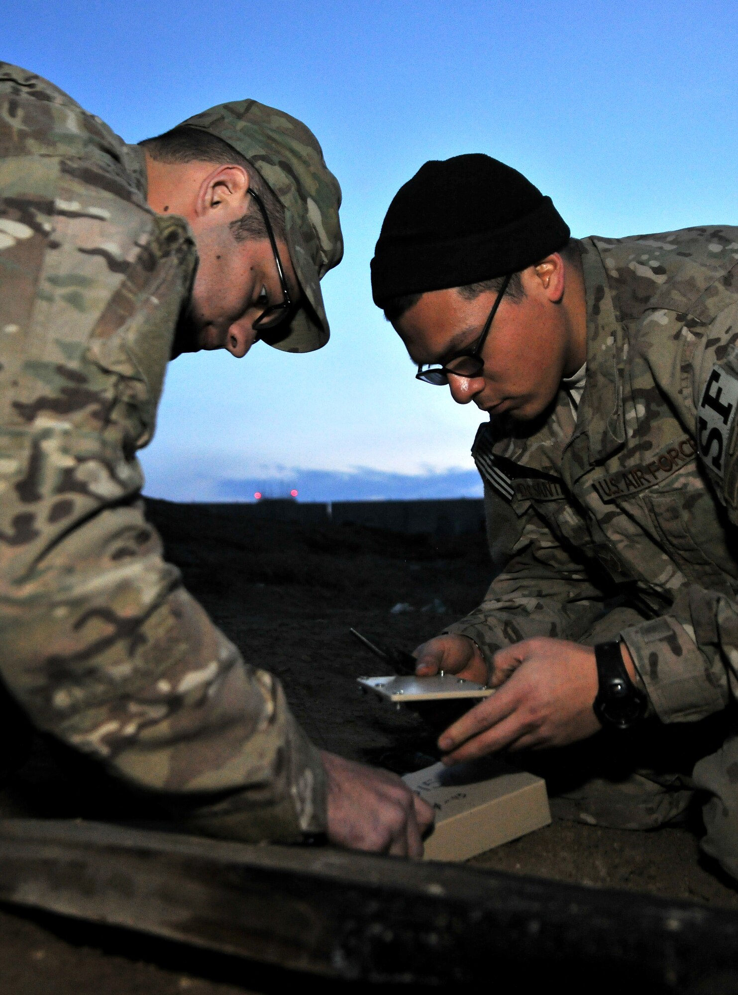 Tech. Sgt. John Dolbee and Staff Sgt. Ben DeSantiago, 755th Expeditionary Security Forces Squadron Reaper team trackers, connect a power source to a ground sensor for an enemy movement and detection training scenario at Bagram Airfield, Afghanistan, Feb. 14, 2013. The team uses a series of search techniques from simple eyes-on to ground sensors to track insurgent activity and provide site exploitation after an attack. (U.S. Air Force photo/Senior Airman Chris Willis)