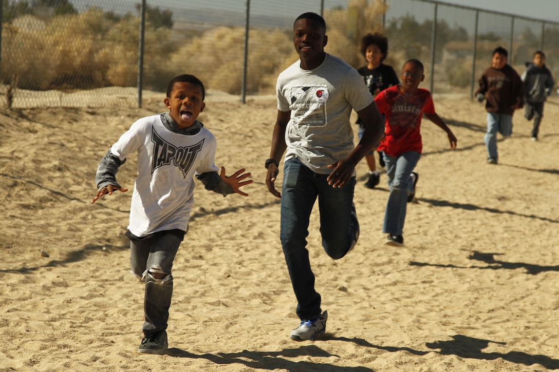 Pfc. Stan Stafford, student, Marine Corps Communication-Electronics School, runs beside Marc Hightower, 4th grader at Condor Elementary School during the kids’ Physical Education class Feb. 6, 2013 as part of the Adopt-a-School Program.