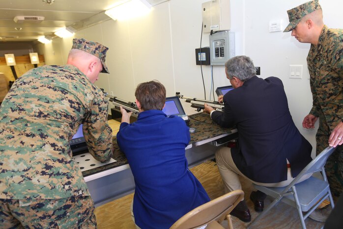Sgt. Brandon E. Koenig, left, and Sgt. Anthony A. Arriaga, right, assist Teddy Bilirakis, center-left, and Rep. Jeff Miller, center-right, with loading air rifles while displaying a variety of recreational sports available to Marines at the Wounded Warrior Hope and Care Center here Feb. 16. 
Koenig and Arriaga are both with Wounded Warrior Battalion West. Miller is the chairman of the House of Veteran Affairs Committee and Bilirakis is the son of the vice chairman.
