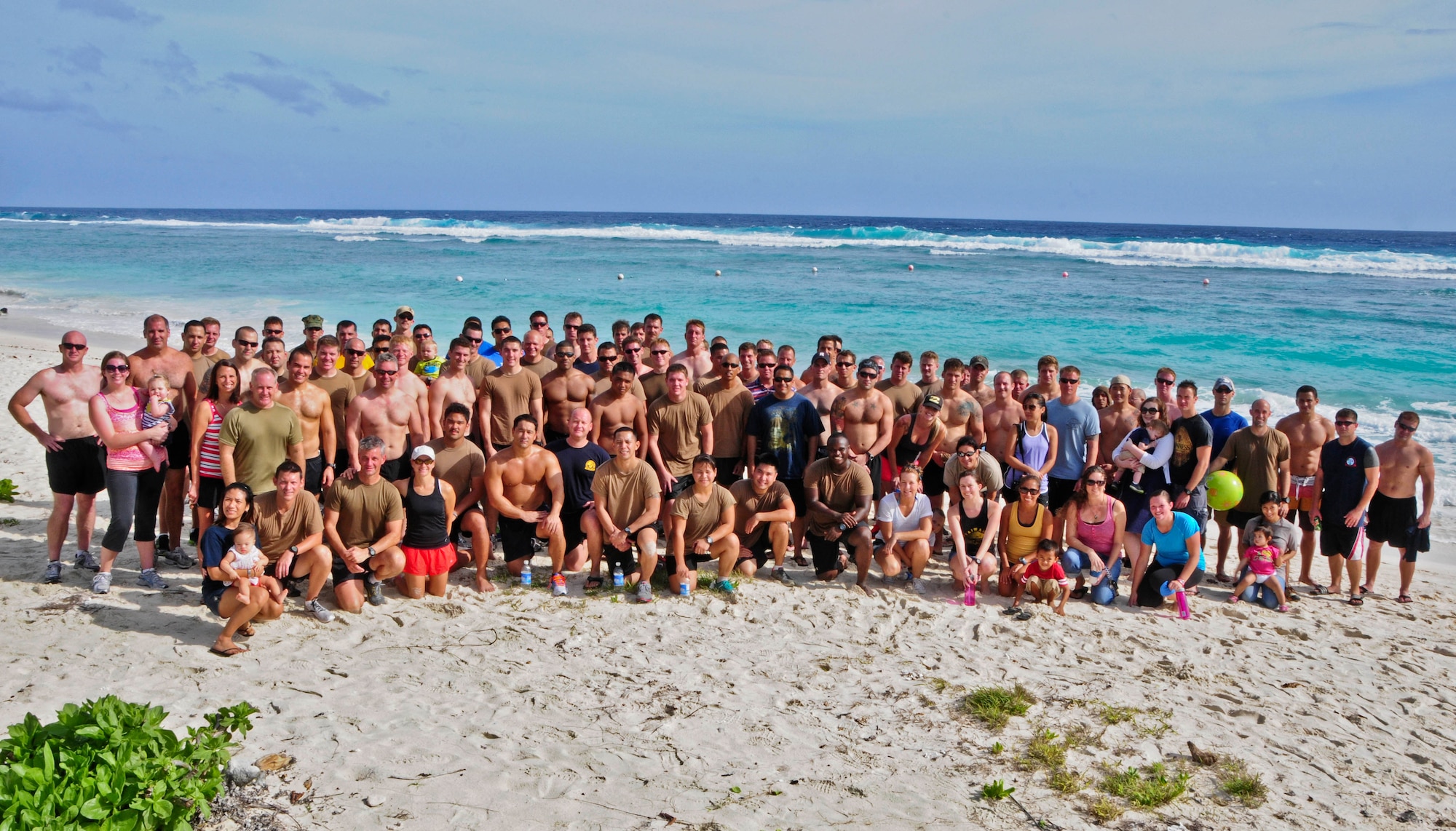 Members of U.S. Navy Explosive Ordnance Disposal Mobile Unit 5 gather on Tarague Beach with their families for a group photo at Andersen Air Force Base, Guam, Feb. 15, 2013. The EODMU5 members and their families took on the challenge of Sanders Slope, from Tarague Beach to the top of the hill and back, as part of their family and morale day. (U.S. Air Force photo by Airman 1st Class Marianique Santos/Released)