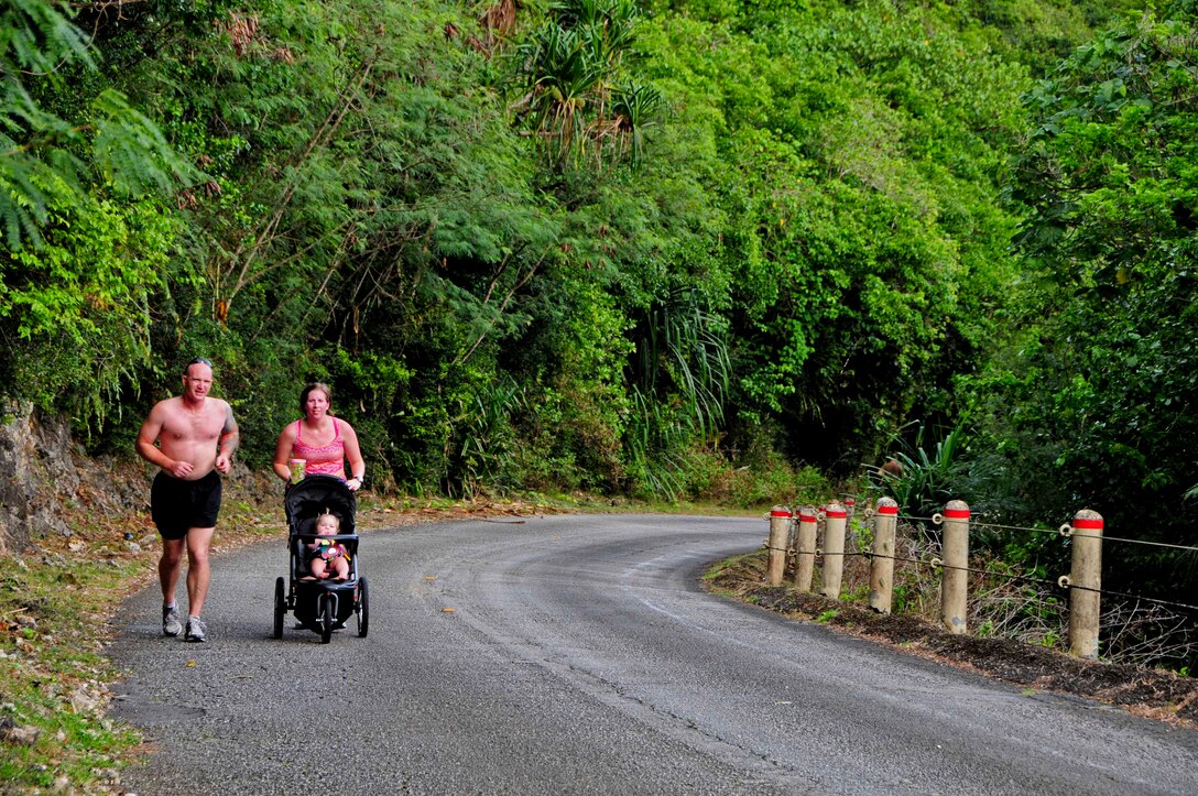 U.S. Navy Petty Officer 1st Class Bobby Schmidtzinsky from Navy Explosive Ordnance Disposal Mobile Unit 5 engineman, runs Sanders Slope with his family at Andersen Air Force Base, Guam, Feb. 15, 2013. The EODMU5 members and their families took on the challenge of Sanders Slope, from Tarague Beach to the top of the hill and back, as part of their family and morale day. (U.S. Air Force photo by Airman 1st Class Marianique Santos/Released)