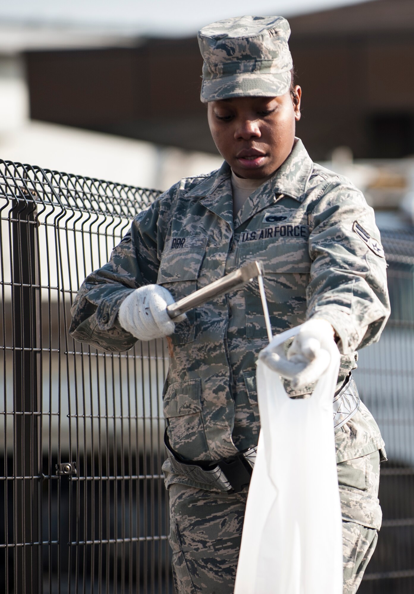 MIZUHO-TOWN, Japan -- Airman 1st Class Nicole Orr, a volunteer from Yokota Air Base, Japan, places plastic in a trash bag Feb. 14, 2013, in Mizuho-town, Japan. Orr and nine other volunteers helped clean up the streets as part of a continuous effort by the 374th Logistical Readiness Squadron to help local communities. (U.S. Air Force photo by Senior Airman Cody H. Ramirez)