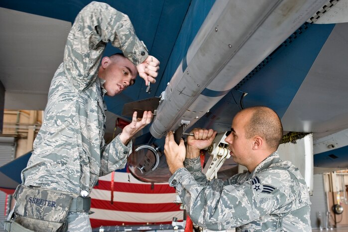 Senior Airman Michael Schena and Senior Airman Christopher Wright, 57th Maintenance Group weapons load crew members, attach fins to an AIM-120C missile on an F-15 Eagle Feb. 15, 2013, at Nellis Air Force Base, Nev. Weapons loaders are responsible for inspections, repairs, and maintenance on aircraft release, launch, suspension and monitor systems of munitions. (U.S. Air Force photo by Senior Airman Matthew Lancaster)