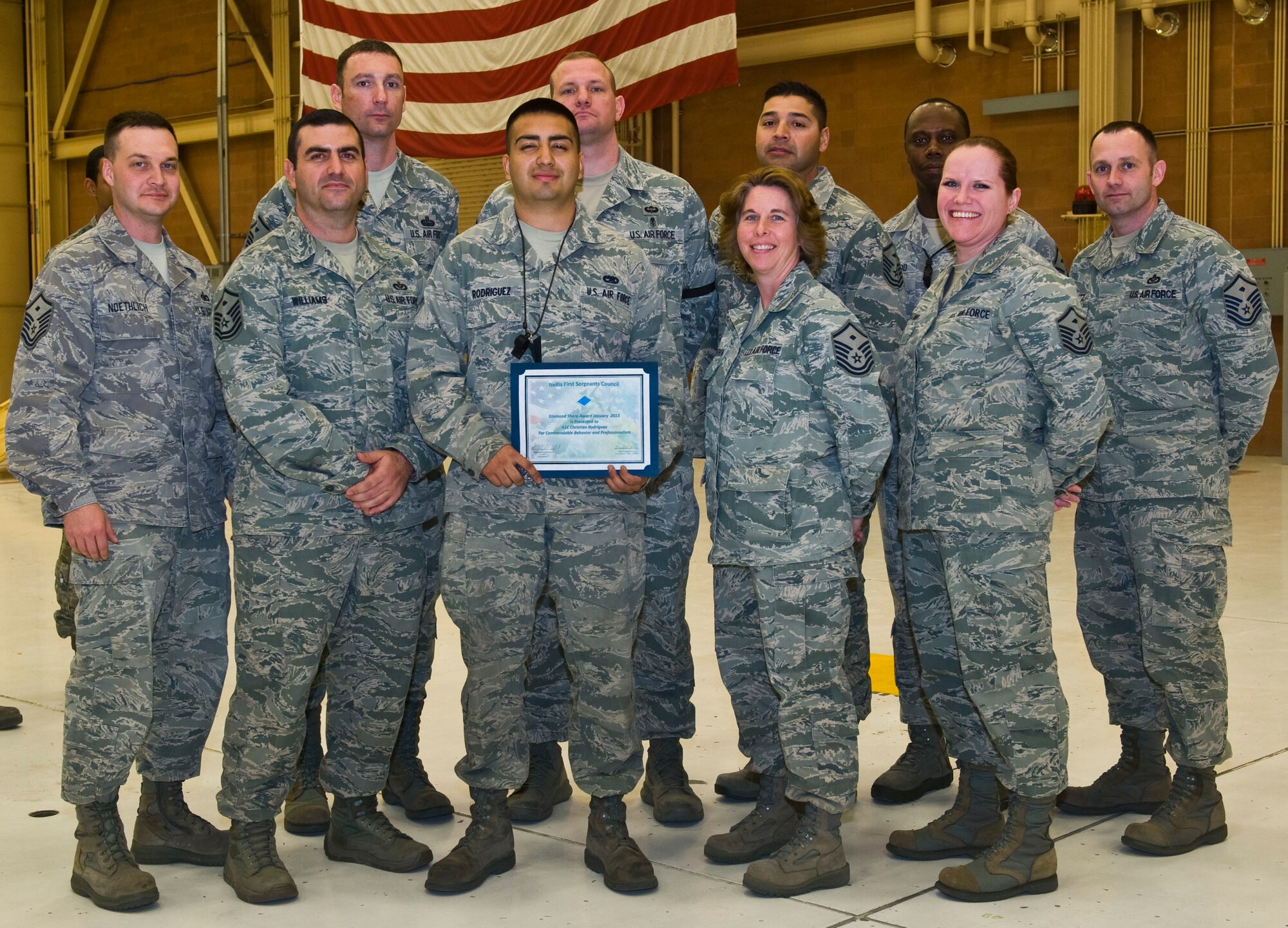 Members of the Nellis First Sergeants' Association present the Diamond Sharp Award to Airman 1st Class Christian Rodriguez, 57th Aircraft Maintenance Squadron crew chief, Feb. 14, 2013, at Nellis Air Force Base, Nev. Rodriguez played a critical role in the F-22 Raptor oxygen modification system, volunteers actively at an animal shelter in Las Vegas and continues to stride towards his Community College of the Air Force degree, recently completing 12 credit hours. (U.S. Air Force photo by Senior Airman Brett Clashman)