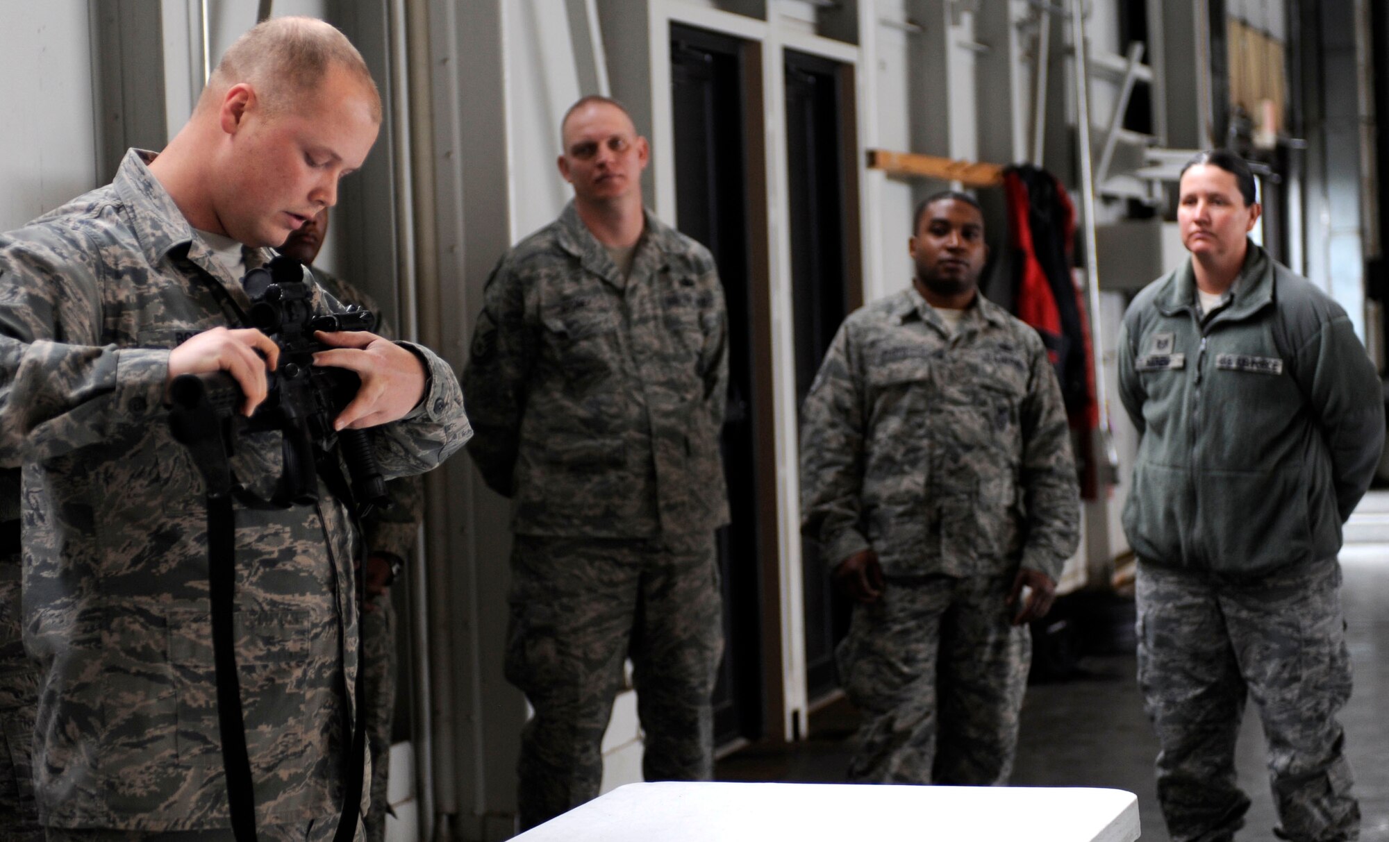 Staff Sgt. Luke Boggs, 28th Security Forces Squadron combat arms instructor, explains the characteristics of an M-4 carbine to Airmen from the 28th Mission Support Group during a 28th MSG deployment readiness exercise in the Pride Hangar at Ellsworth Air Force Base, S.D., Feb. 14, 2013. The purpose of the training session was to educate Airmen about the firearm as a way of ensuring they are prepared for possible deployment scenarios. (U.S. Air Force photo by Airman Ashley J. Thum/Released)
