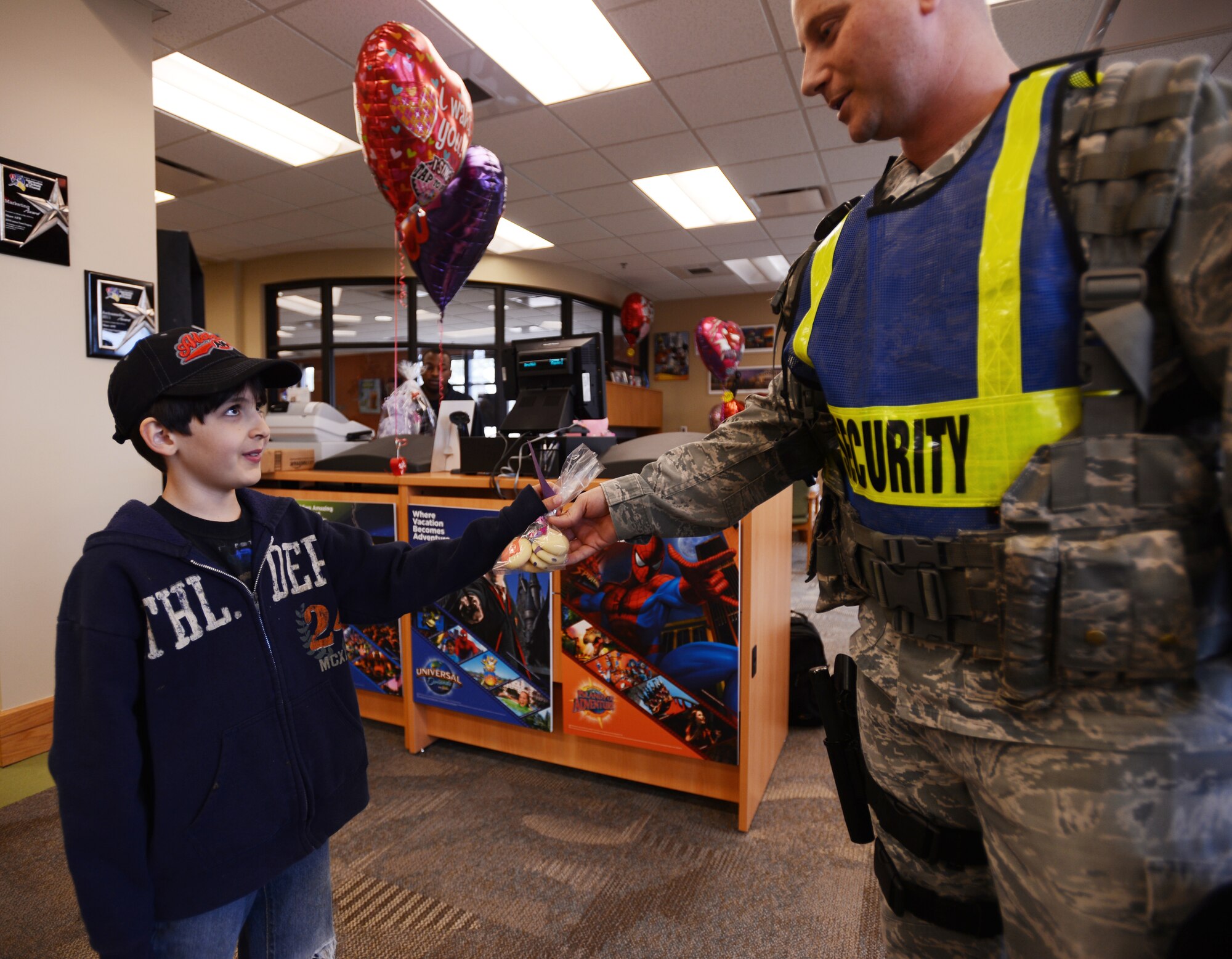 Weston Hook, son of Jenise Hook and Michael Hook, gives Valentine's Day cookies to U.S. Air Force Tech. Sgt. Kevin Gambler, 20th Security Forces Squadron flight chief, at McElveen Resource Center, Shaw Air Force Base, S.C., Feb. 14, 2013. Weston visited numerous places around base with his mother Jenise and brother Joseph wishing people a happy Valentine's Day and giving out cookies. (U.S. Air Force photo by Senior Airman Tabatha Zarrella/Released)
