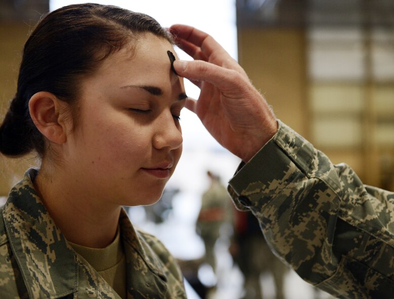 U.S. Air Force Chaplain Richard Fitzgerald, 20th Fighter Wing Chaplain, places a cross of ashes on the forehead of Airman 1st Class Samantha Urdiales, 20th Civil Engineer Squadron operations manager, during exercise Weasel Victory 13-03 at Shaw Air Force Base, S.C., Feb. 13, 2013. Chaplains from Palmetto Chapel on base participated in the exercise to ensure that players were able to partake in Ash Wednesday. Ash Wednesday is a traditional religious event mostly practiced by Catholics. (U.S. Air Force photo by Senior Airman Tabatha Zarrella/Released)
