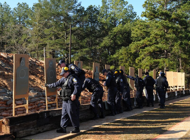 Department of the Air Force police officers setup their targets at the Bossier Parish Sheriff's Office firing range in Plain Dealing, La., Feb. 14. DAF officers are government employees who must go through rigorous and strict training, and must meet the physical, medical and weapon proficiency standards to be hired. (U.S. Air Force photo/Airman 1st Class Benjamin Gonsier)
