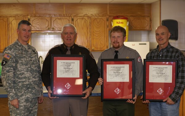 From left to right, Col. Michael Teague, Tulsa District commander presents lifesaving awards to Trooper Danny Choate, Ranger Chris Gilliland and Ranger Eric Fassio. The three were recognized for their efforts to save two individuals that were stranded in the river below Eufaula Dam last summer. 