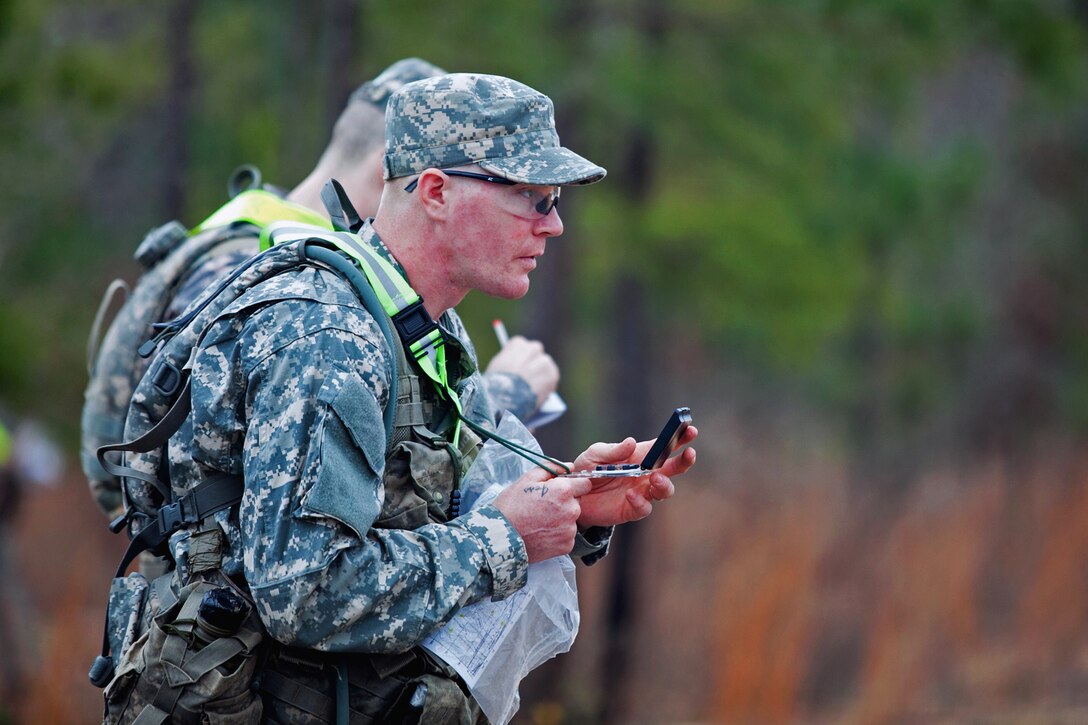 Canadian Army Cpl. Jonathan Schmidt, front, an international military student, checks his compass before the Land Navigation Training Exercise during a ranger training assessment course at the National Guard Warrior Training Center on Fort Benning, Ga., Feb. 10, 2013.