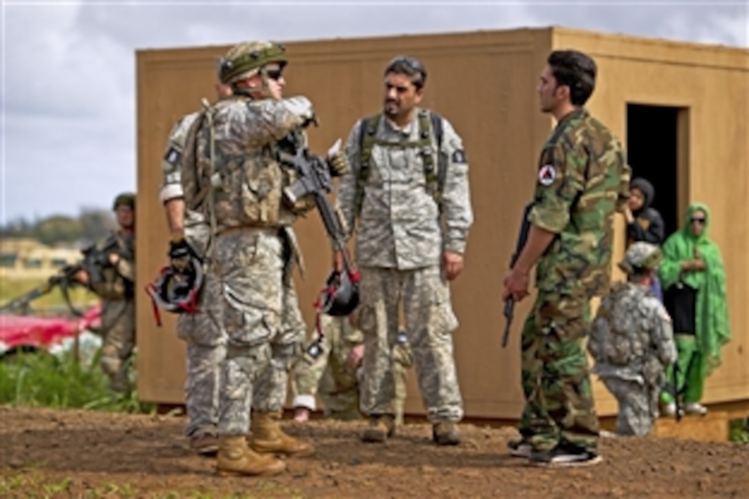 Army Capt. Kyle Burns, left, speaks with a role player acting as an Afghan soldier at a mock Afghan village during exercise Warrior Spear on Schofield Barrack in Wahiawa, Hawaii, Feb. 5, 2013. Burns is commander, 25th Infantry Division’s Company C, 1st Battalion, 14th Infantry Regiment, 2nd Stryker Brigade Combat Team. 