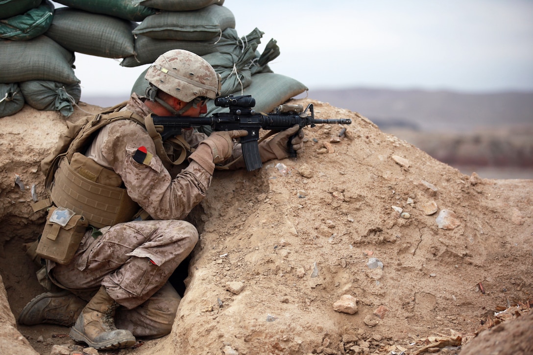 Lance Cpl. Ryan Howerton, a 22-year-old native of Kansas City, Mo., and mortar man with Echo Company, 2nd Battalion, 7th Marine Regiment, searches for insurgents during an Afghan National Civil Order Police-led operation Feb. 13. Marines with 2nd Bn., 7th Marines provided fire support during the operation.

