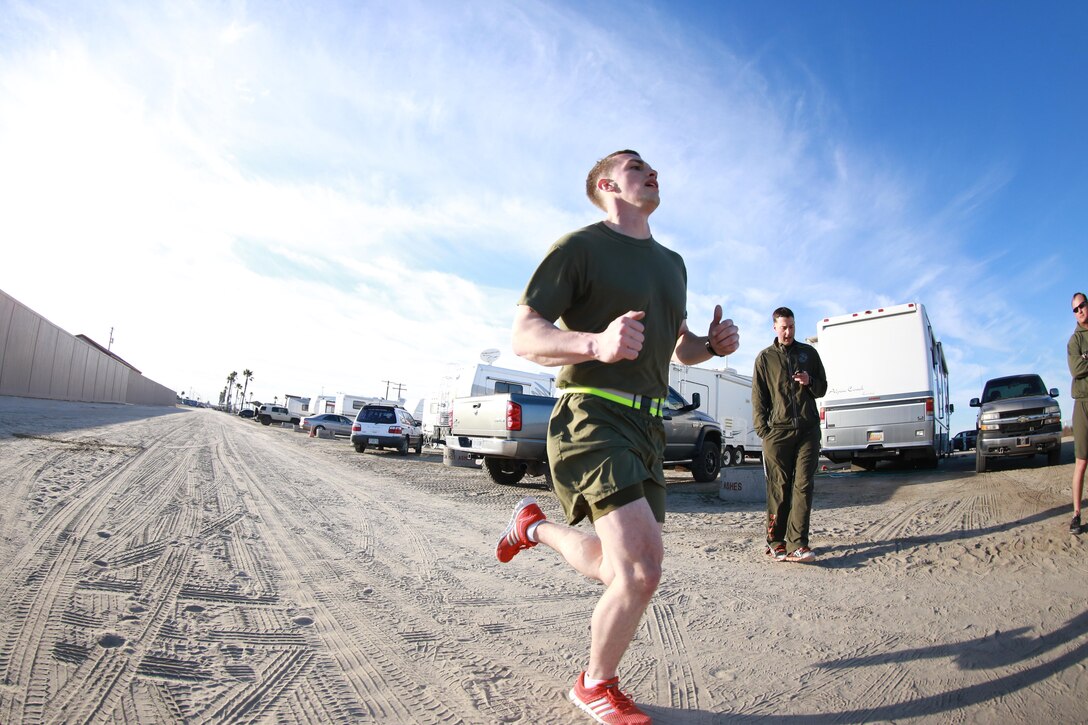 Camp Pendleton, Calif. - 2nd Lieutenant Brendan McIntyre, 11th Marine Expeditionary Unit Deputy Public Affairs Officer, crosses the finish line during the 3-mile run event of the unit's physical fitness test here 15 Feb. 2013. The Command Element of the 11th MEU is currently in the post deployment period of the deployment cycle. (U.S. Marine Corps photo by Gunnery Sgt. Chance W. Haworth/RELEASED)