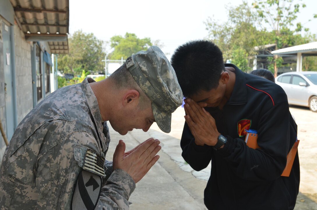 U.S. Army Lt. Col. Shawn Creamer, commander of Amy 2nd Battalion, 9th Infantry Regiment, 1st Armored Brigade Combat Team, 2nd Infantry Division,  thanks 2nd Lt. Panyasit Painkeo, of the Royal Thai Army 104th Heavy Artillery Unit, for his hospitality and his tour of his unit's King's Program farm Feb. 9 at Camp A in Phitsanulok province, Kingdom of Thailand, prior to the start of exercise Cobra Gold 2013. At the conclusion of the tour, Creamer presented Painkeo with a "Manchu" battalion coin. Joint and multinational training is vital to maintaining the readiness and interoperability of all participating military forces.
