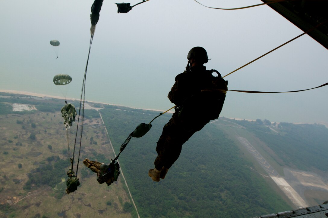 U.S. and Royal Thai Marines parachute out of a KC-130J Hercules aircraft while conducting bilateral aerial delivery training during exercise Cobra Gold 2013 near Utapao Royal Thai Navy Air Field, Kingdom of Thailand, Feb. 15. The Marines participated in the training to enhance the two nations' combat readiness and military-to-military cooperation. The U.S. Marines are with 3rd Marine Reconnaissance Battalion, 3rd Marine Division, III Marine Expeditionary Force.