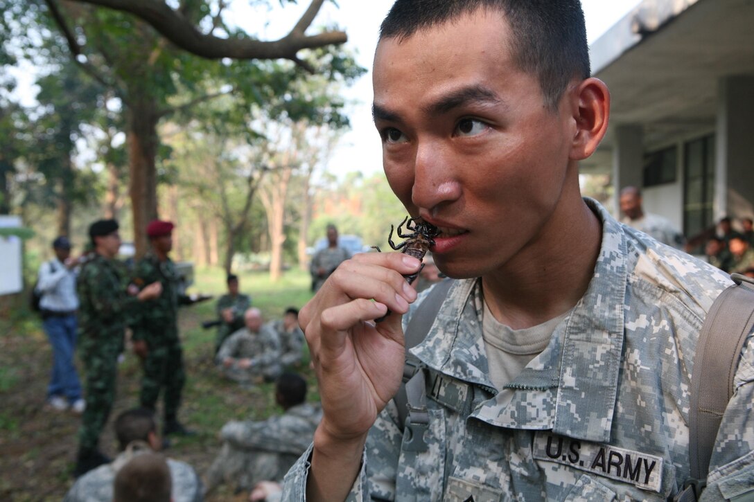 U.S. Army Staff Sgt. Jialong Li eats a roasted cockroach as part of a jungle survival class Feb. 17 at Camp Akatosrot, Phitsanulok province, Kingdom of Thailand, as part of exercise Cobra Gold 2013. Li is an infantryman with Baker Company, 2nd Battalion, 9th Infantry Regiment, 1st Armored Brigade Combat Team, 2nd Infantry Division. Exercise Cobra Gold includes humanitarian and civic assistance projects, a staff exercise and field training exercises. Joint and multinational training is vital to maintaining the readiness and interoperability of all participating military forces.