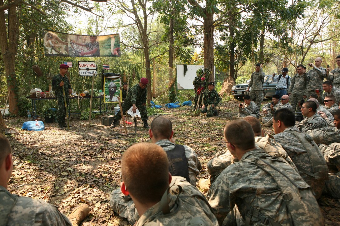 Royal Thai Army Special Forces Master Sgt. 1st Class Thong Nimnuan, center, demonstrates how to safely approach and handle a cobra as part of a jungle survival class Feb. 17 at Camp Akatosrot, Phitsanulok province, Kingdom of Thailand, during exercise Cobra Gold 2013. Thai soldiers attending the class are with 7th Regiment, 7th Division, 3rd Region, Royal Thai Army. U.S. soldiers are with Baker Company, 2nd Battalion, 9th Infantry Regiment, 1st Armored Brigade Combat Team, 2nd Infantry Division. U.S. involvement in CG 13 demonstrates commitment to building military-to-military interoperability with participating nations and to supporting peace and stability in the region.