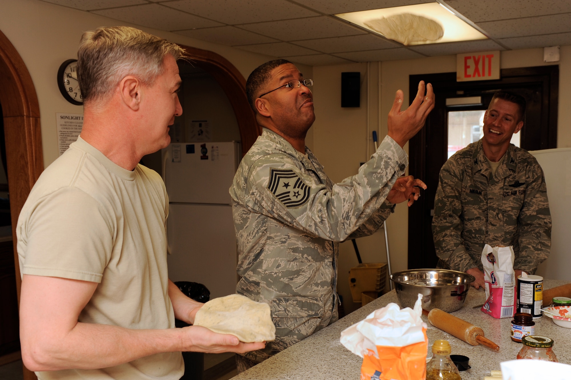 Chief Master Sgt. Phillip Robinson, 8th Fighter Wing command chief, tosses pizza dough in the air during a cooking class at Kunsan Air Base, Republic of Korea, Feb. 20, 2013. This program has been encouraging Airmen to learn healthy cooking techniques for ten years.  (U.S. Air Force photo by Senior Airman Marcus Morris/Released)