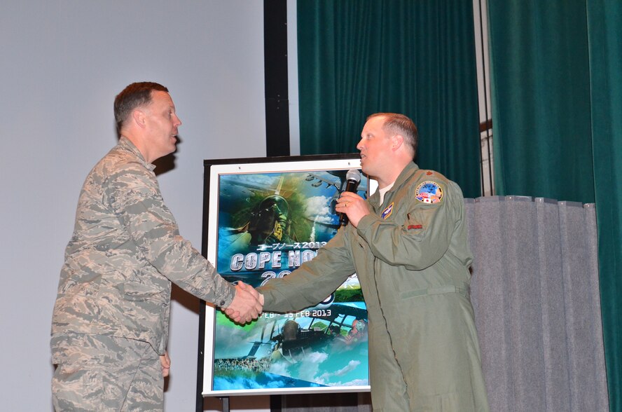 (Left) U.S. Air Force Brig. Gen. Steven Garland, 36th Wing commander, is greeted on stage by (Right) Maj. John Greven, 5th Air Force exercise planner and Cope North 13 operations lead, during the exercise closing ceremony at Andersen Air Force Base, Guam Feb. 15. Cope North 13 was conducted on Andersen, as well as the surrounding islands of Tinian and Saipan from Feb. 4-15. 72 aircraft from the U.S. Air Force, U.S. Navy, Japan Air Self-Defense Force and Royal Australian Air Force participated in the exercise. 1,897 personnel from 20 units assisted in allowing those aircraft to fly 823 sorties over the course of the two-week exercise. (U.S. Air Force photo by Staff Sgt. Alexandre Montes/Released)