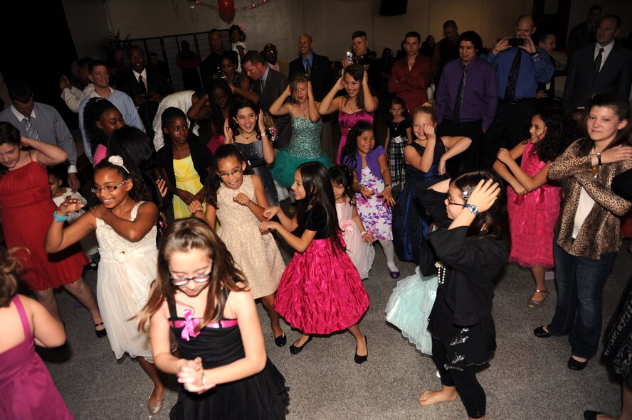 Girls dance to the "Macarena" at the father-daughter dance on Kadena Air Base, Japan, Feb. 16, 2013. The dance was hosted by the Shogun Defenders, an 18th Security Forces Squadron booster club, at Ryukyu Middle School last year, which received positive feedback after the event, encouraging future father-daughter dances. (U.S. Air Force photo/Airman 1st Class Hailey R. Davis)