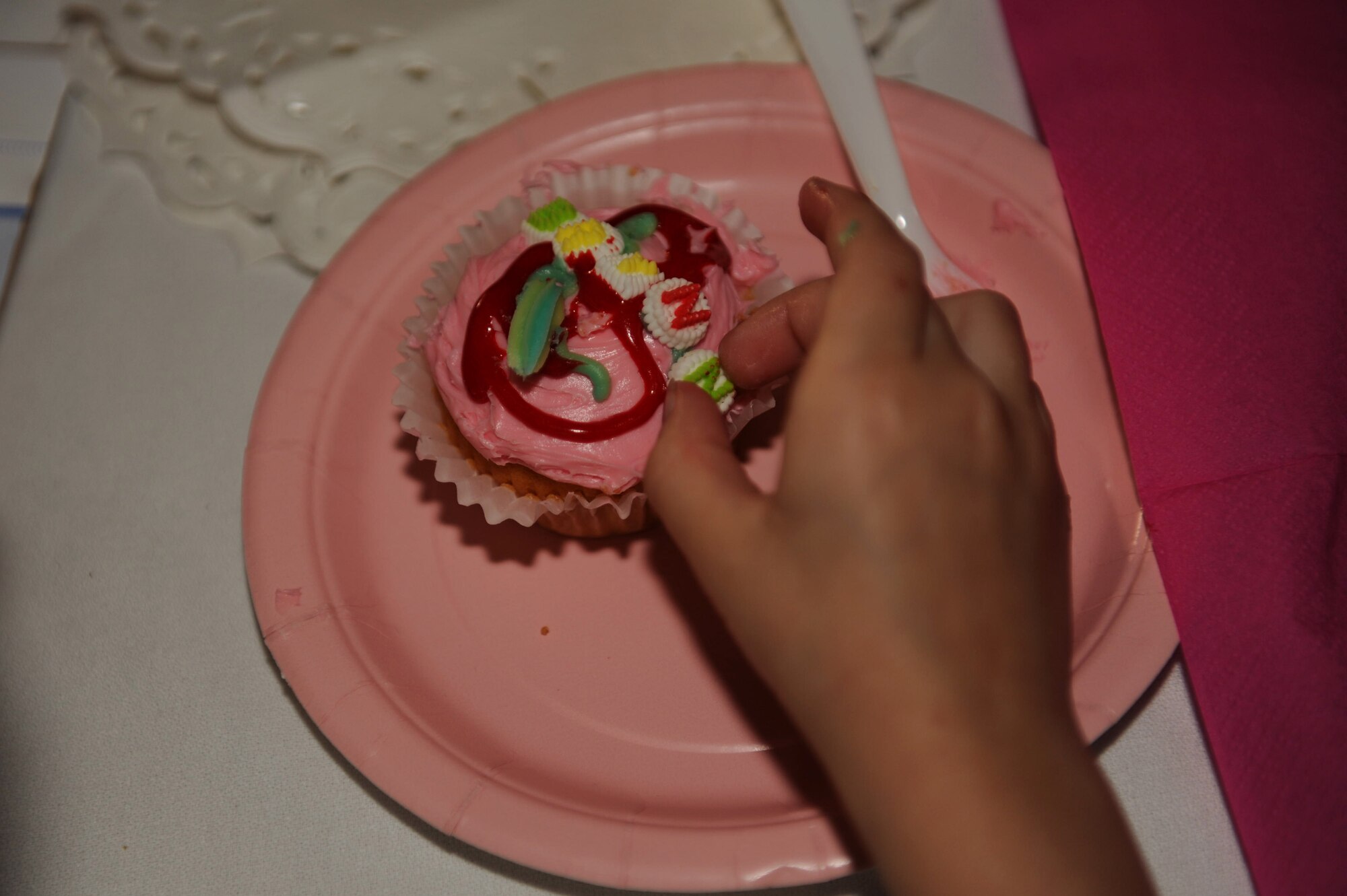 A daughter places the last letter of her name on a cupcake during the father-daughter dance on Kadena Air Base, Japan, Feb. 16, 2013. The dance was hosted by the Shogun Defenders, an 18th Security Forces Squadron booster club, at Ryukyu Middle School last year. The club received positive feedback after the event, encouraging future father-daughter dances. (U.S. Air Force photo/Airman 1st Class Hailey R. Davis)