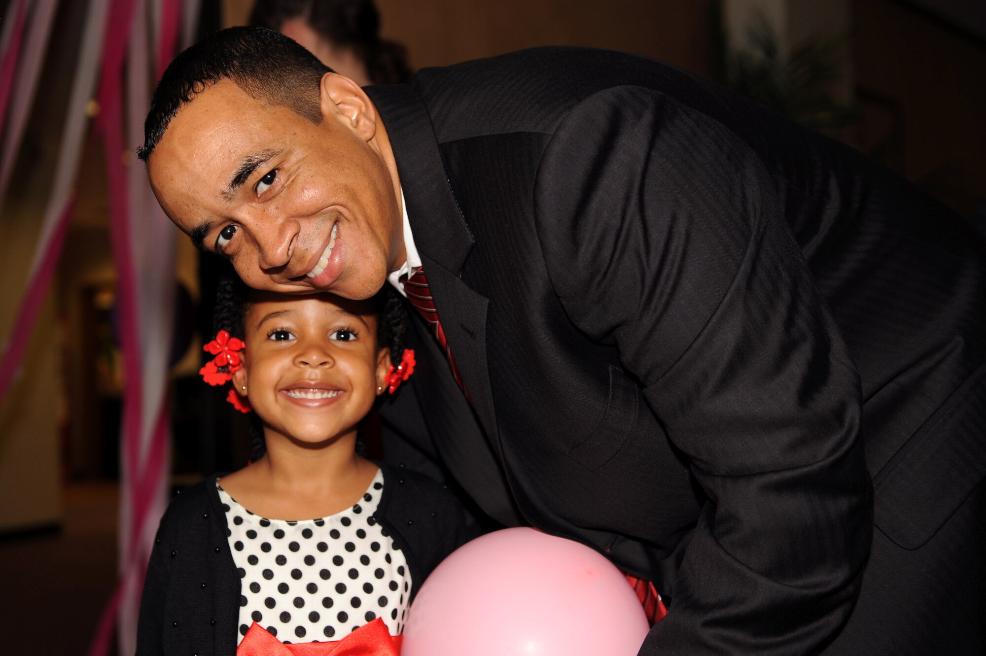 U.S. Air Force Maj. John Nolan, 18th Logistics Readiness Squadron operations officer, takes a photo with his daughter Gabriella at the father-daughter dance on Kadena Air Base, Japan, Feb. 16, 2013. Gabriella won a cake during a cake-walk event at the dance. (U.S. Air Force photo/Airman 1st Class Hailey R. Davis)