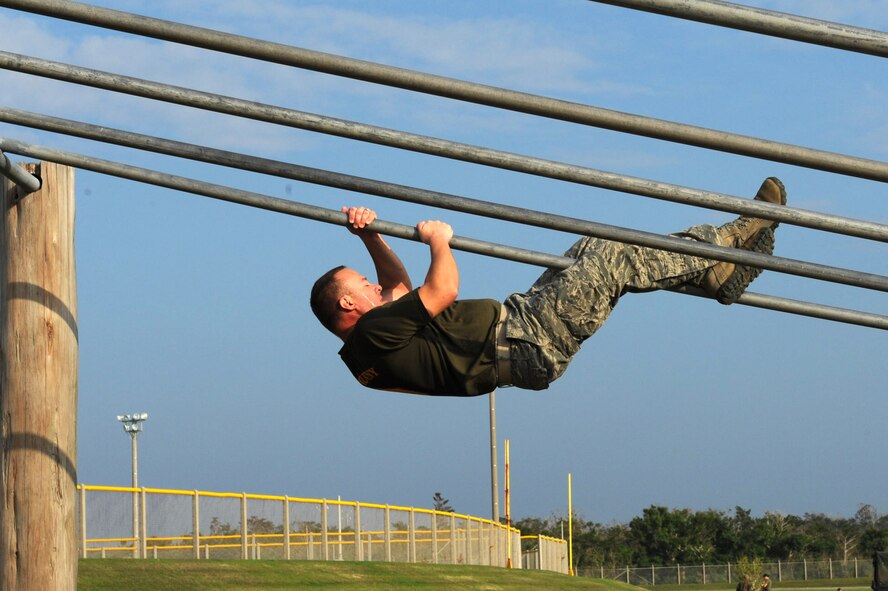 U.S. Air Force Master Sgt. Brian Bartles, 18th Civil Engineer Group Fire and Emergency Services superintendent of operations, slides down a pole during a confidence course on Camp Hansen, Japan, Feb. 14, 2013. Thirty-three senior NCO service members participated in the course, followed by a squad competition where three teams competed against each other. (U.S. Air Force photo/Airman 1st Class Hailey R. Davis)