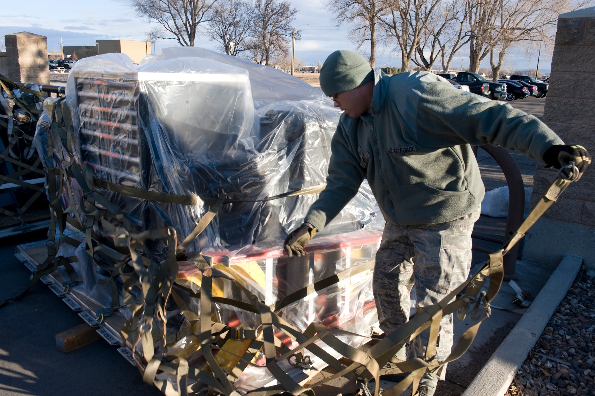 U.S. Air Force Senior Airman Jomar Rivera, 389th Aircraft Maintenance Unit crewchief, pulls off a cargo net from a pallet of equipment Feb. 19, 2013, at Mountain Home Air Force Base, Idaho. Rivera unloaded all of the equipment previously packed during a base-wide operational readiness exercise, Sharpshooter 13-2. (U.S. Air Force photo/Airman 1st Class Brittany Chase)