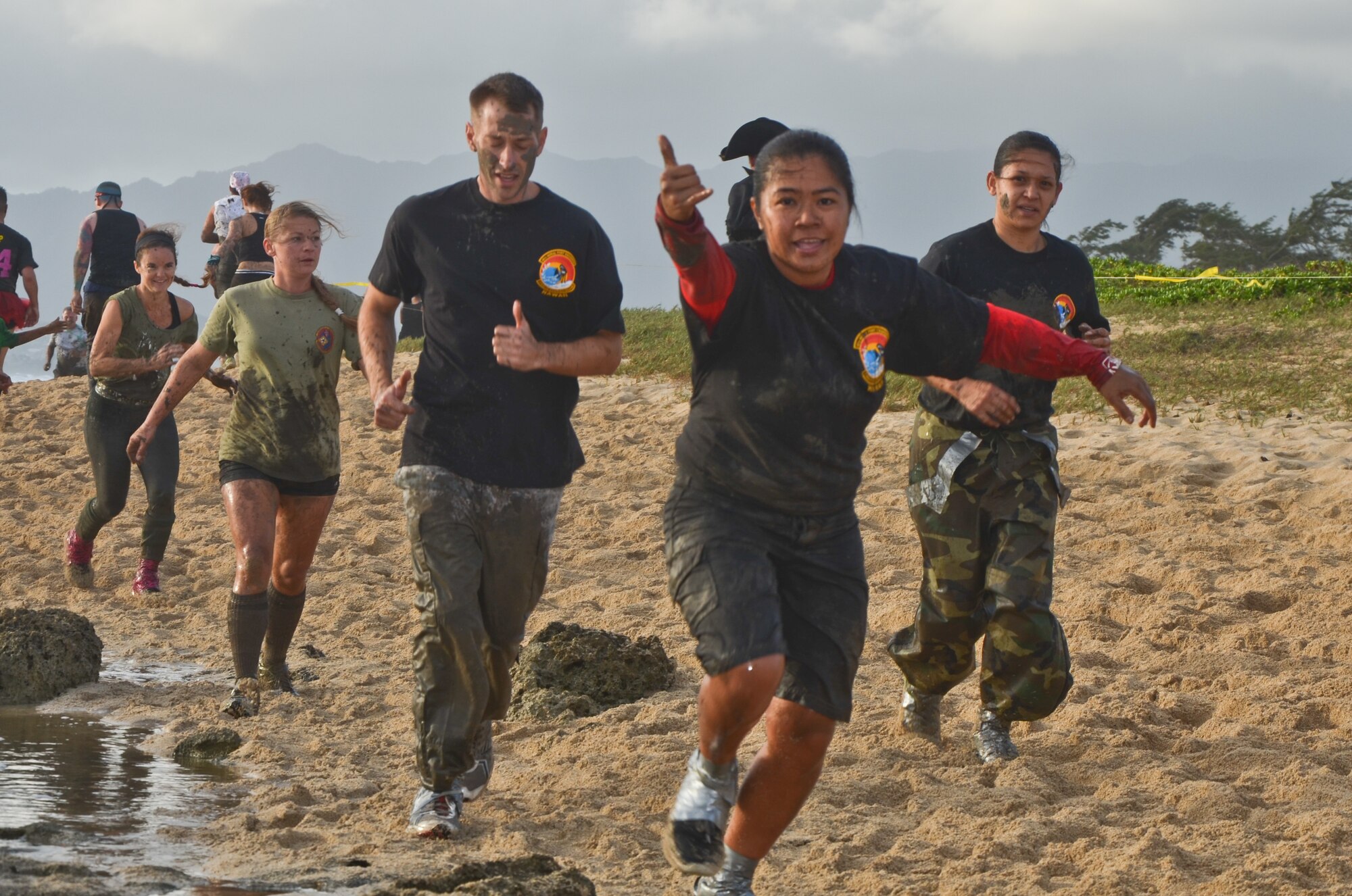 Senior Airman Rechelle L. Ancheta, center, an air transportation craftsman with the 48th Aerial Port Squadron, flashes a shaka sign as she runs on Fort Hase Beach with teammates 2nd Lt. Jeremy K. Rhode, left center, an air transportation officer with the 48th APS, and Tech. Sgt. Jahnna K. Burns, right center, an air transportation craftsman with the 48th APS, at the 19th Annual Swamp Romp, at Marine Corps Base Hawaii, Kaneohe Bay, Hawaii, Saturday, Feb. 16, 2013. The shaka sign, commonly known as "hang loose", is a gesture often associated with Hawaii and surfer culture. Hawaiian locals use the shaka to convey the "Aloha Spirit," a gesture of friendship and understanding between the various ethnic cultures that reside within Hawaii. (U.S. Air Force photo/Tech. Sgt. Phyllis E. Keith)