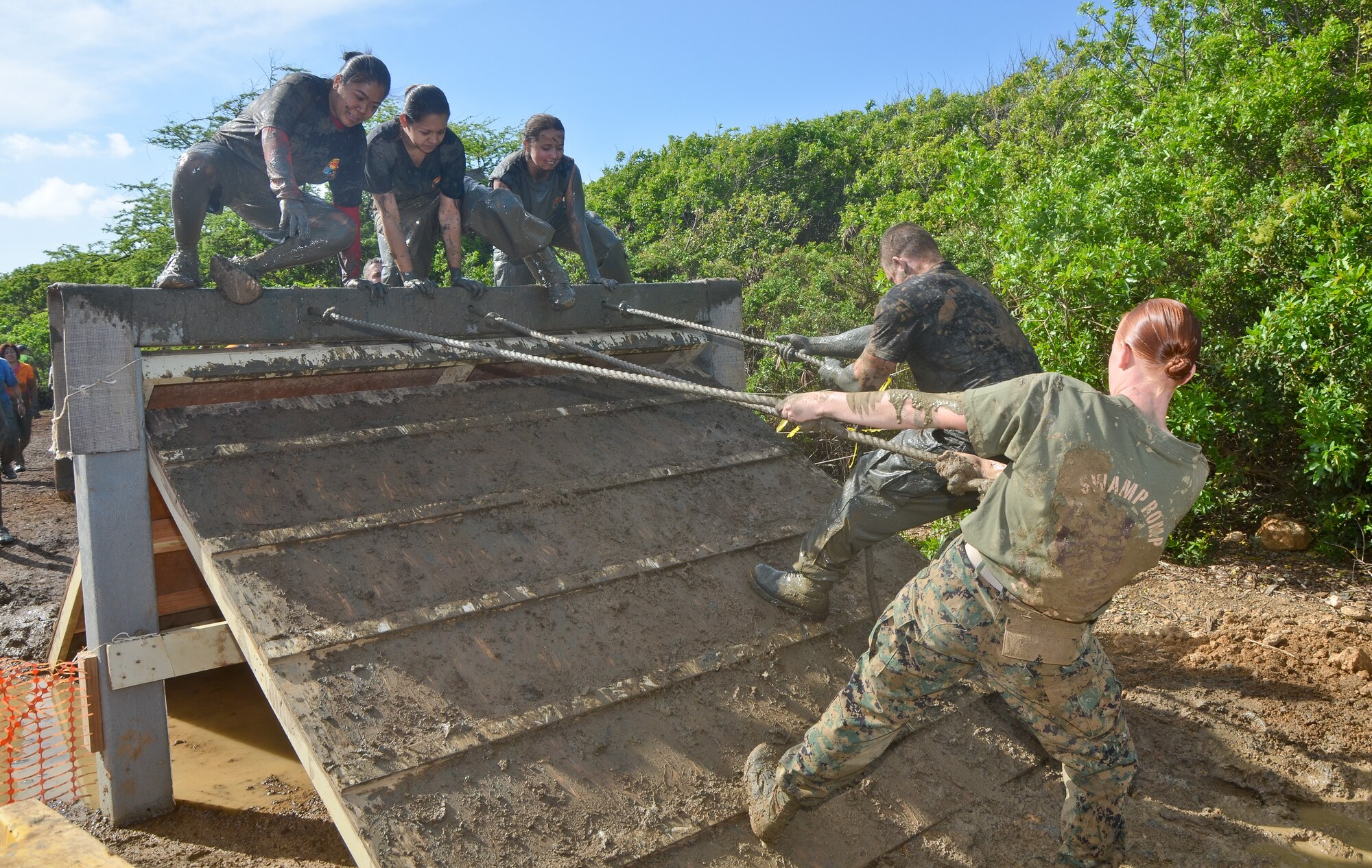 From top left, Senior Airman Rechelle L. Ancheta, an air transportation craftsman with the 48th Aerial Port Squadron, 624th Regional Support Group, Joint Base Pearl Harbor-Hickam, Hawaii, Tech. Sgt. Jahnna K. Burns, also an air transportation craftsman with the 48th APS, and 2nd Lt. Janet M. Hudson, chief of personnel for the 624th RSG, climb over the last obstacle in the 19th Annual Swamp Romp, at Marine Corps Base Hawaii, Kaneohe Bay, Hawaii, Saturday, Feb. 16, 2013. The 5-mile footrace, affectionately called “the dirtiest race of the year,” takes runners through mud, water, dirt and sand, and over and under obstacles that challenge even the fittest of the fit. The annual Swamp Romp is open to service members and civilians, and is one of eleven races that make up the MCBH Commanding Officer’s Fitness Series. (U.S. Air Force photo/Tech. Sgt. Phyllis E. Keith)