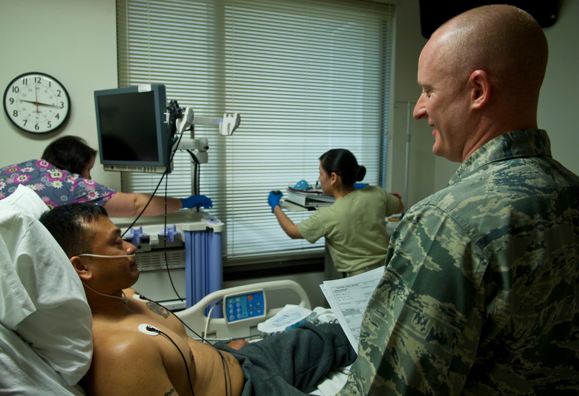 Master Sgt. Darwin Mallari (left), Headquarters Air Combat Command command support staff superintendent, and 1st Lt. Adam Garrison, 633rd Medical Group critical care nurse, discuss Mallari’s bronchoscopy, Feb. 12, 2013 at U.S. Air Force Hospital Langley, Va. Immediately after the procedure, Mallari was released to his family. (U.S. Air Force photo by Airman 1st Class Austin Harvill/Released)