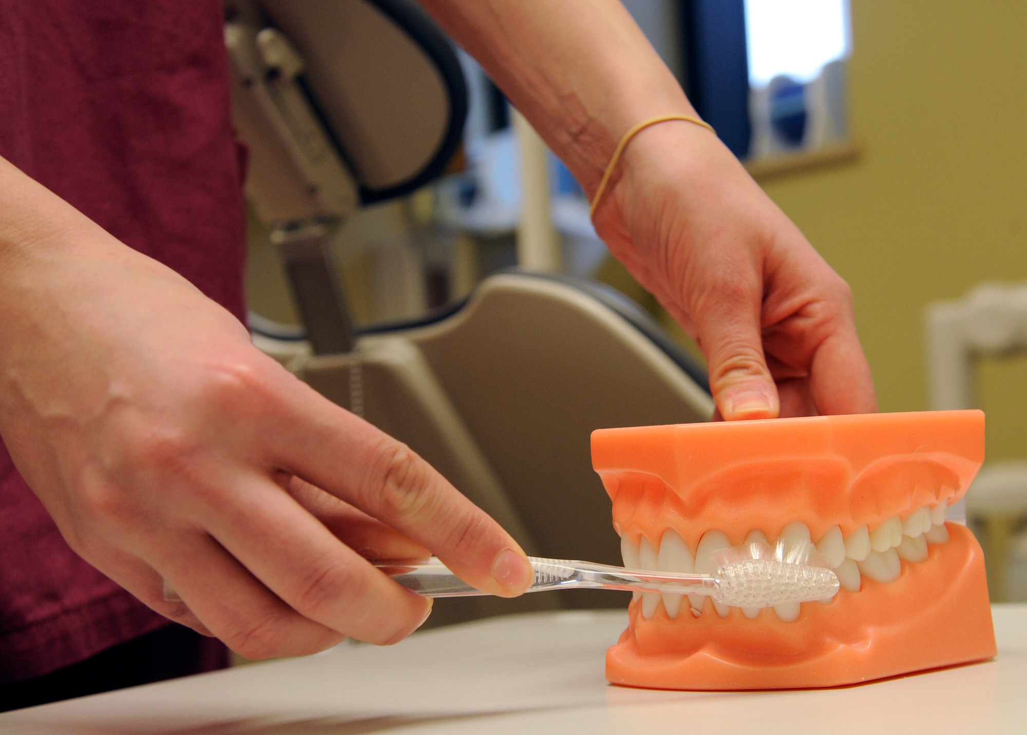Senior Airman Jacqueline Motz, 92nd Medical Group dental technician, demonstrates the proper brushing techniques on a pair of imitation dentures at the dental clinic at Fairchild Air Force Base, Wash., Feb. 19, 2013. Avoiding unnecessary high sugar content fluids such as fruit juice, sports drinks and soda will not only benefit your child’s dental health but also their overall general health. (U.S. Air Force photo by Airman 1st Class Ryan Zeski)