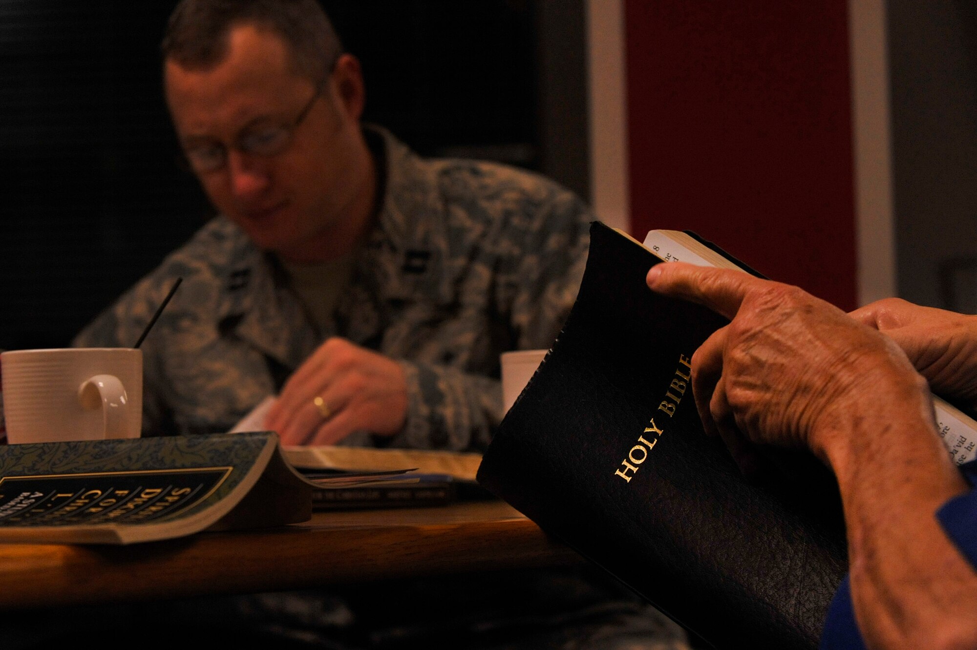Chaplain (Capt.) Garrell Calton, a 19th Airlift Wing chaplain, participates in a bible study inside the Crossroads Cafe Dec. 20, 2012, at Little Rock Air Force Base, Ark. Calton holds the bible study every Thursday. (U.S. Air Force photo by Airman 1st Class Rusty Frank)