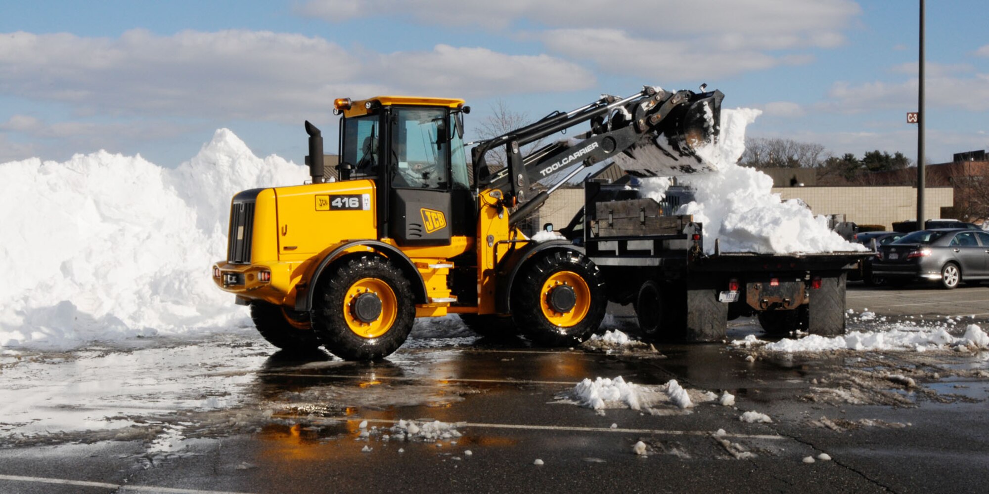 HANSCOM AIR FORCE BASE, Mass. – Civil Engineering crews remove snow from the Hanscom Exchange and Commissary parking lots Feb. 14. Nearly two weeks after Winter Storm Nemo and on top of additional snow fall, CE has been working to clear snow piles from roads, parking lots, sidewalks and other areas around the base. (U.S. Air Force photo by Linda LaBonte Britt)
