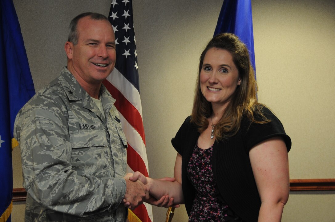 Heather Arnold of the 372nd Training Squadron receives an award from Brig. Gen. Michael Fantini. Arnold was congratulated on her community service and help with children. 