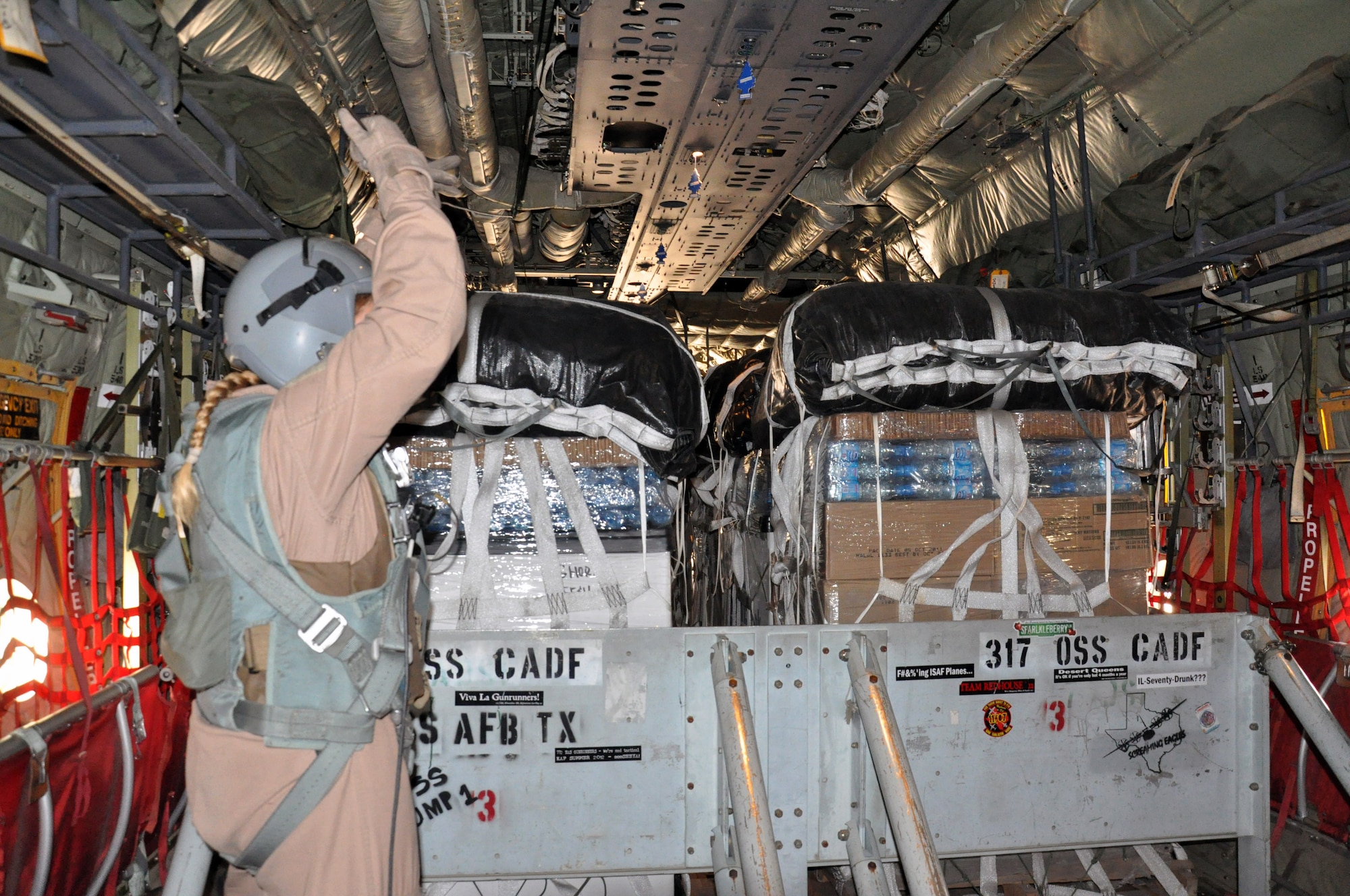 Master Sgt. Tracey Smith, 772nd Expeditionary Airlift Squadron loadmaster, prepares to release an airdrop containing food and fuel for troops from a C-130J Feb. 14, 2013, above southern Afghanistan. Smith is one of many deployed 317th Airlift Group Airmen from Dyess Air Force Base, Texas, currently assigned to the 772nd EAS. (U.S. Air Force photo by Capt. Tristan Hinderliter/Released)