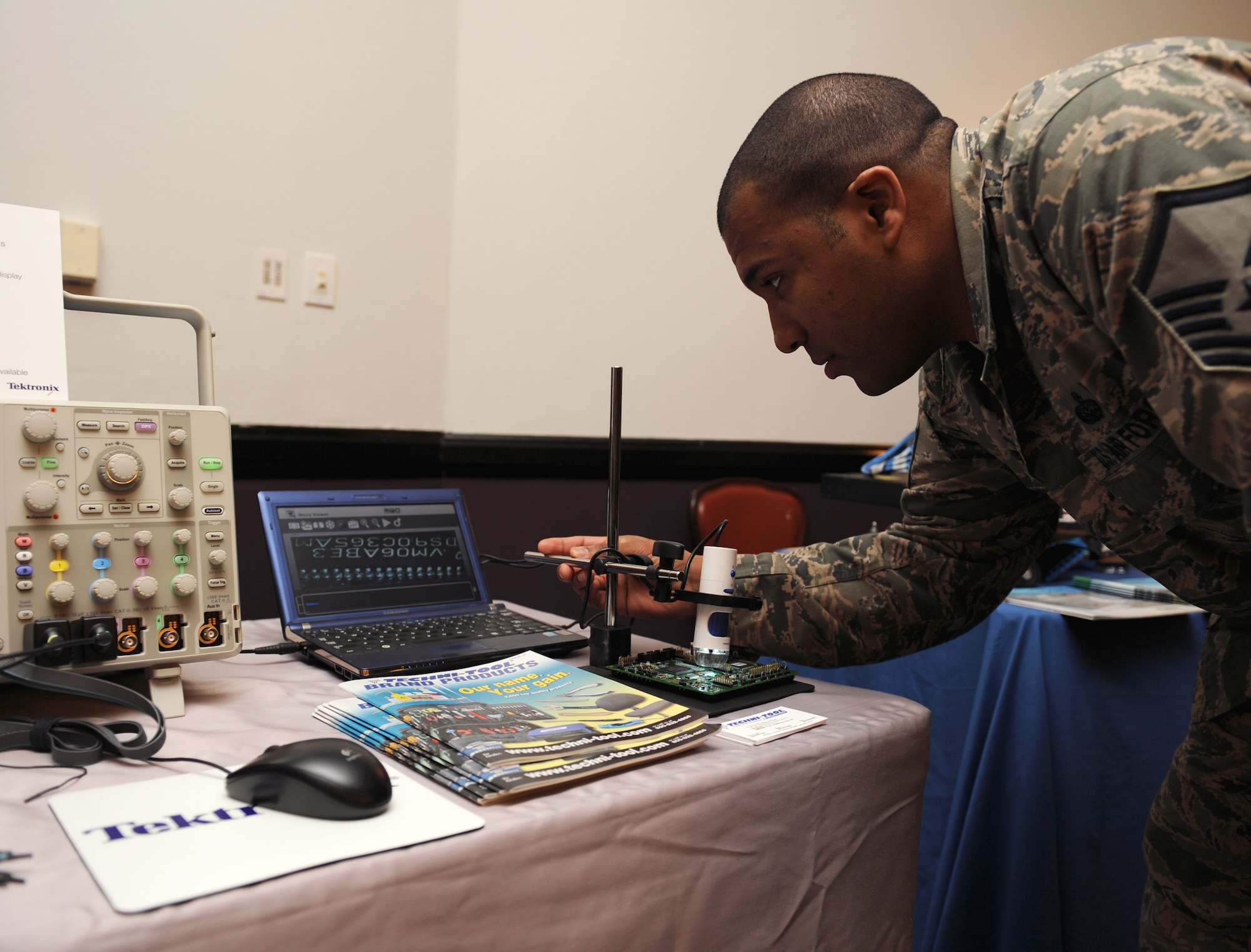 Master Sgt. Mario Rodriguez, 608th Air Communications Squadron, looks at a microviewer during the Information Technology Expo on Barksdale Air Force Base, La., Feb. 19. The microviewer enables the user to magnify a piece of equipment and document any damage. (U.S. Air Force photo/Airman 1st Class Benjamin Gonsier) 
