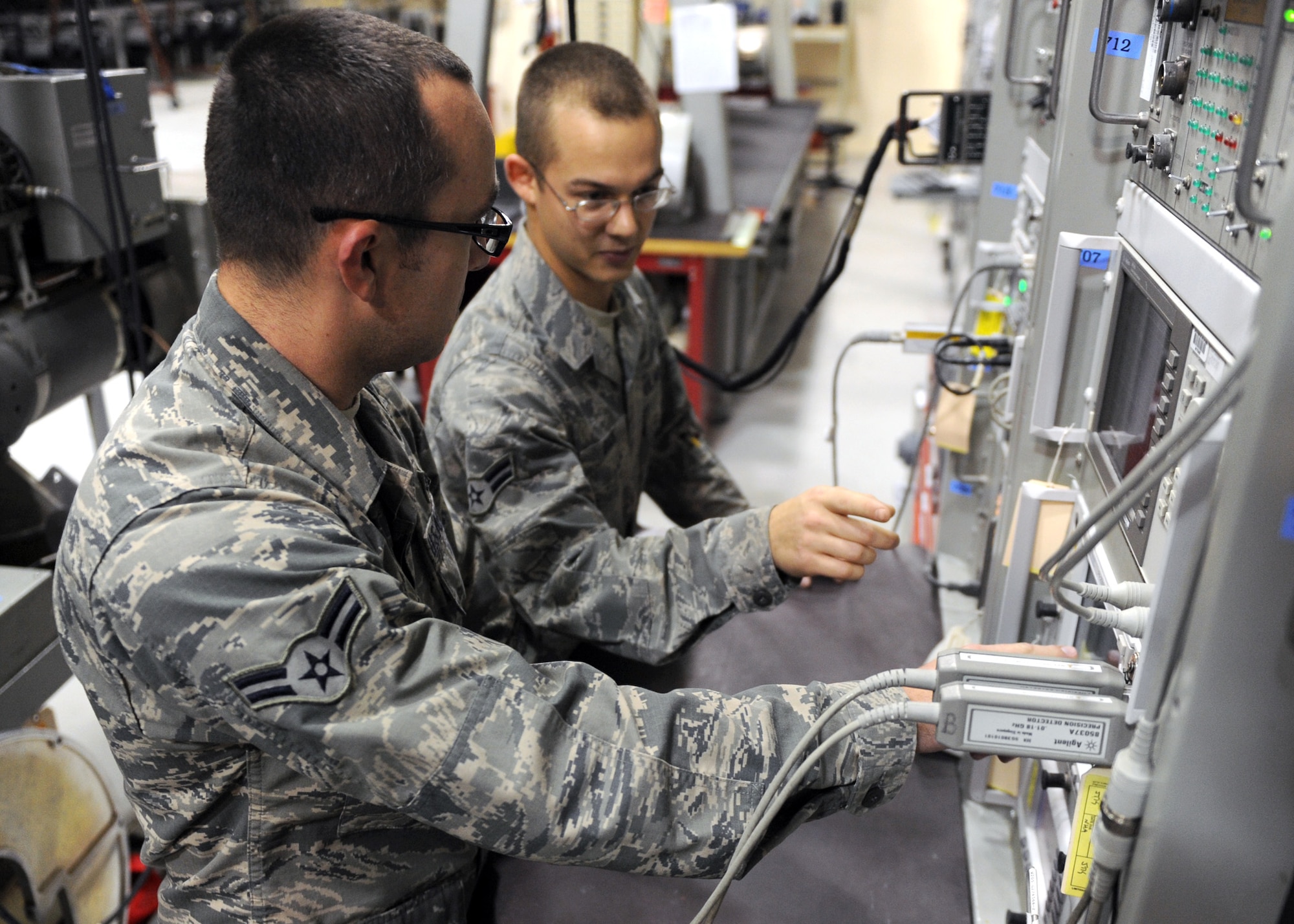 SOUTHWEST ASIA – From left, Airman 1st Class Tyler Whitmore and Airman 1st Class Jonathan Buck work on a test station to make sure an electronic warfare pod is up to standards Feb. 19. Because of the sensitivity of the pods they have to be inspected every 120 days. Both Airmen are assigned to the 379th Expeditionary Squadron. Whitmore is deployed from the 355th Component Maintenance Squadron at Davis Monthan Air Force Base, Ariz. Buck is deployed from the 20th CMS at Shaw Air Force Base, S.C. (U.S. Air Force photo/Senior Airman Joel Mease)