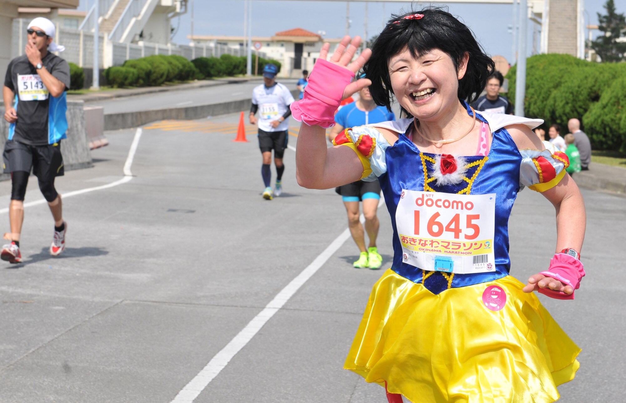 A participant, dressed as Snow White, waves while running in the 2013 Okinawa Marathon on Kadena Air Base, Japan, Feb.17, 2013. More than 11,000 runners, including those who dressed creatively for the marathon, ran the 46-km race and brought cheers from hundreds of volunteers. (U.S. Air Force photo/Airman 1st Class Keith A. James)
