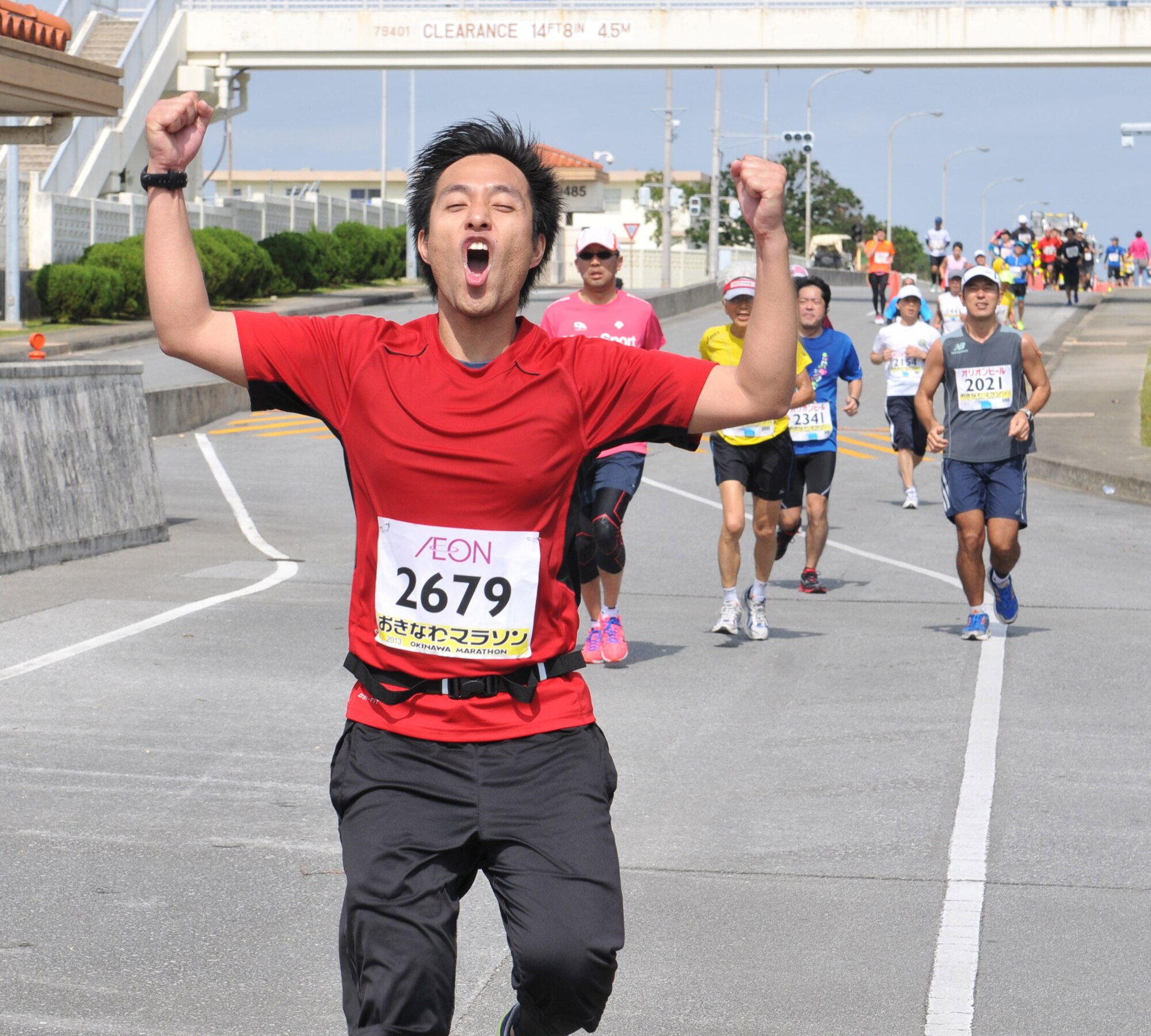 A runner celebrates while making his way toward Kadena's Gate 5 on Kadena Air Base, Japan, Feb.17, 2013.The route was 42 km, including 2.8 km inside Kadena. Hundreds of volunteers handed out water and cheered the runners on throughout the race. (U.S. Air Force photo/Airman 1st Class Keith A. James)