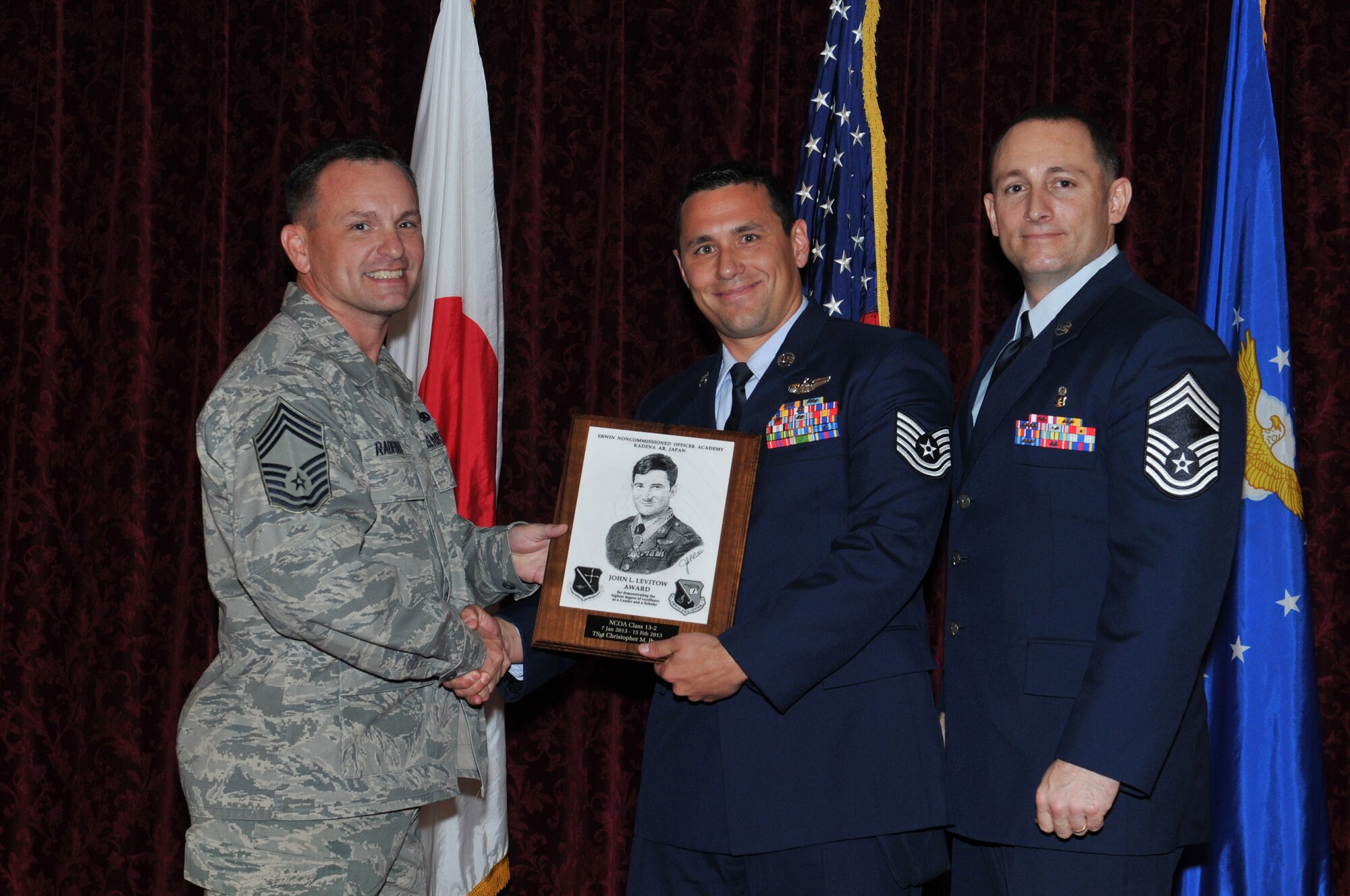 U.S. Air Force Chief Master Sgt. Michael Radford, 18th Equipment Maintenance
Squadron Flight chief, and guest speaker Chief Master Sgt. Thomas Stiles,
18th Dental Squadron superintendent, present the John L. Levitow award to
Tech. Sgt. Christopher Peacock, from the 390th Intelligence Squadron, at
the NCO Academy Class 13-2 graduation on Kadena Air Base, Japan, Feb. 15,
2013. The distinguished graduate award, sponsored by the Kadena Chiefs
group, is named in memory of Medal of Honor recipient Airman 1st Class John
L. Levitow. The award is presented to the most outstanding member of
enlisted professional military education graduates and denotes superior
achievement as both a leader and a scholar. (U.S. Air Force photo/Airman 1st
Class Keith A. James)