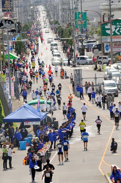 Runners exit Kadena's Gate 5, ending the base's portion of the 2013 Okinawa Marathon on Kadena Air Base, Japan, Feb. 17, 2013. Team Kadena supported the Okinawa Marathon by providing 2.8 km of the 42-km marathon route. Hundreds of volunteers also supported more than 11,000 runners in the race. (U.S. Air Force photo/Staff Sgt. Darnell T. Cannady)