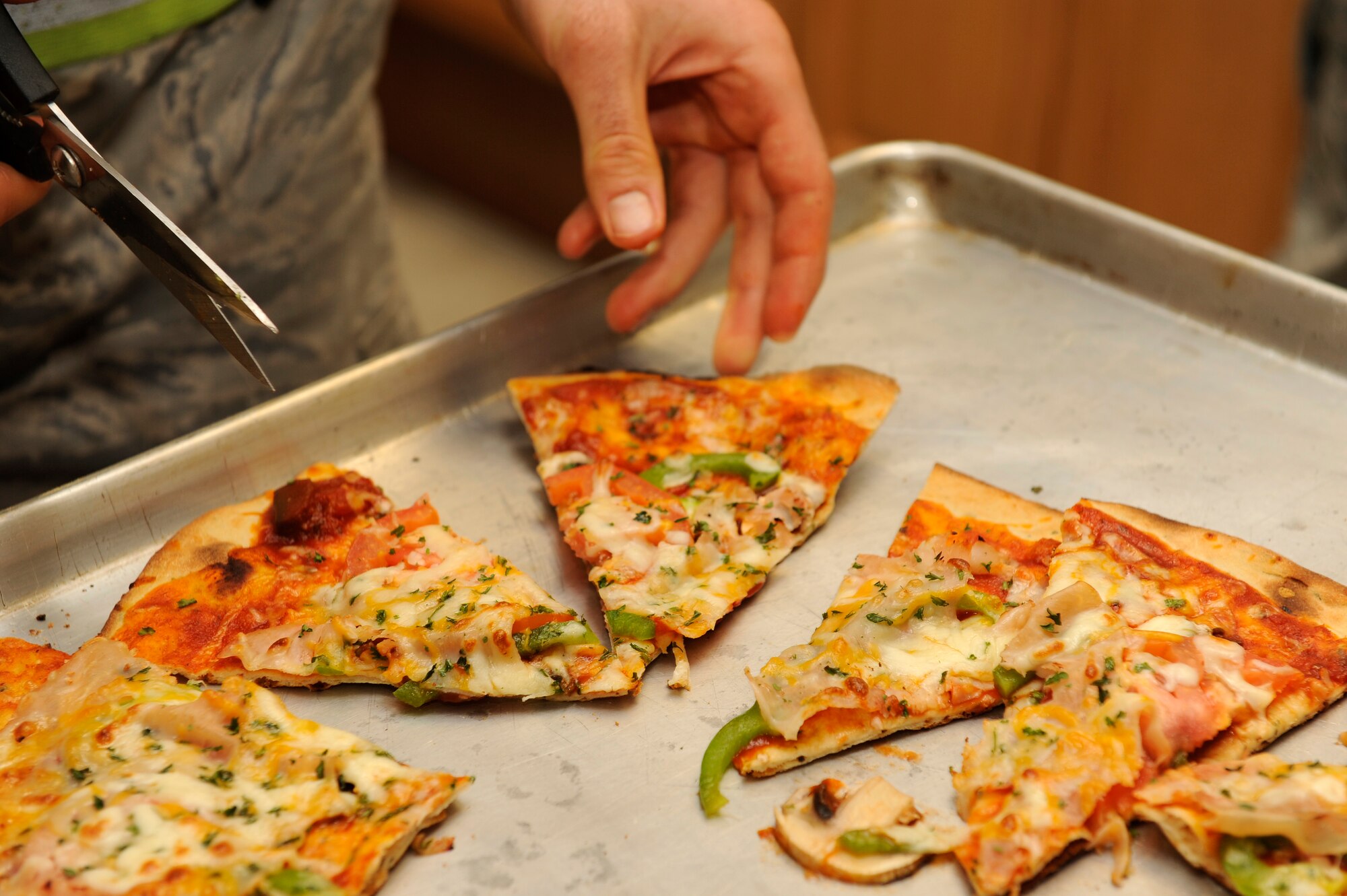 Staff Sgt. Jeffery Furbush, 8th Maintenance Squadron, cuts up a pizza during a cooking class at Kunsan Air Base, Republic of Korea, Feb. 20, 2013. The class is held once a month and features a different dish each time. (U.S. Air Force photo by Senior Airman Marcus Morris/Released)