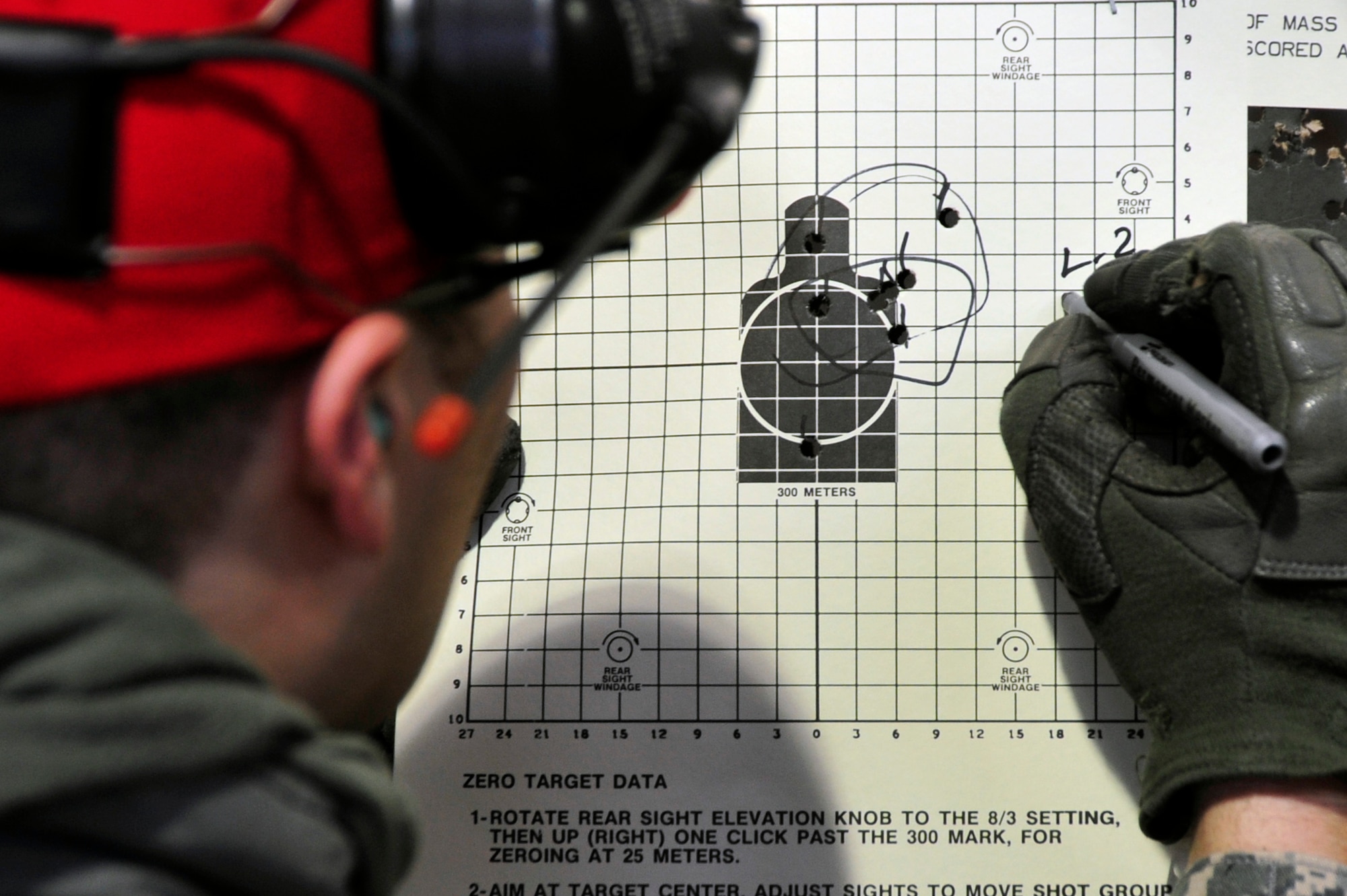 Staff Sgt. Matthew Marquart, 51st Security Forces Squadron combat arms instructor, marks a target to assist a student in zeroing his weapon during a new and improved qualification course at the combat arms range at Osan Air Base, Republic of Korea, Jan. 31, 2013. CATM cadres teach anywhere from 50-100 Airmen a week during the course which covers weapon safety, maintenance and operation. In addition to standard security forces training, CATM instructors must go through a three-month course to become certifiable. (U.S. Air Force photo/Airman 1st Class Alexis Siekert)