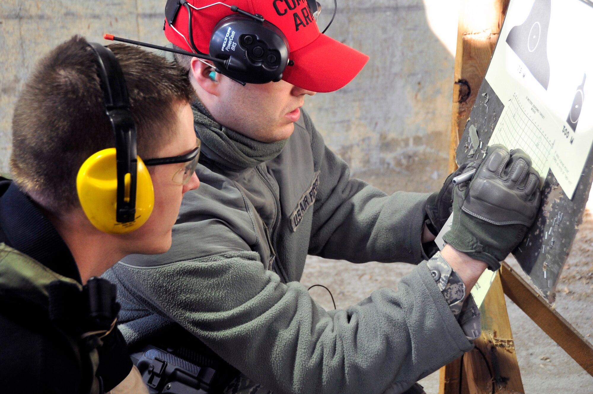 Staff Sgt. Matthew Marquart, 51st Security Forces Squadron combat arms instructor, marks a target to assist a student in zeroing his weapon during a new and improved qualification course at the combat arms range at Osan Air Base, Republic of Korea, Jan. 31, 2013. CATM cadres teach anywhere from 50-100 Airmen a week during the course which covers weapon safety, maintenance and operation. The instructor team is made up of only six Airmen. (U.S. Air Force photo/Airman 1st Class Alexis Siekert)