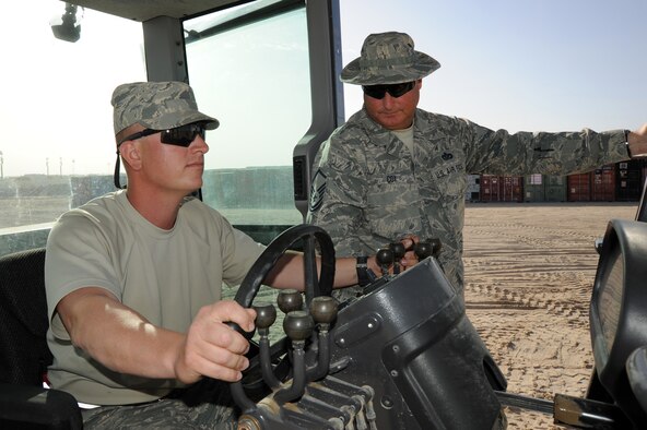 Senior Airman Kyle Paridee and Master Sgt. Shane Cox, 386th Civil Engineering Squadron operate inside a grader at a deployed base in Southwest Asia Feb. 18, 2013. The Dirt Boyz construct and maintain concrete and asphalt runways, aircraft parking aprons, and roads using a variety of heavy construction equipment, such as, loaders, graders, dozers, backhoes, and dump trucks. (U.S. Air Force photo by Senior Master Sgt. George Thompson)